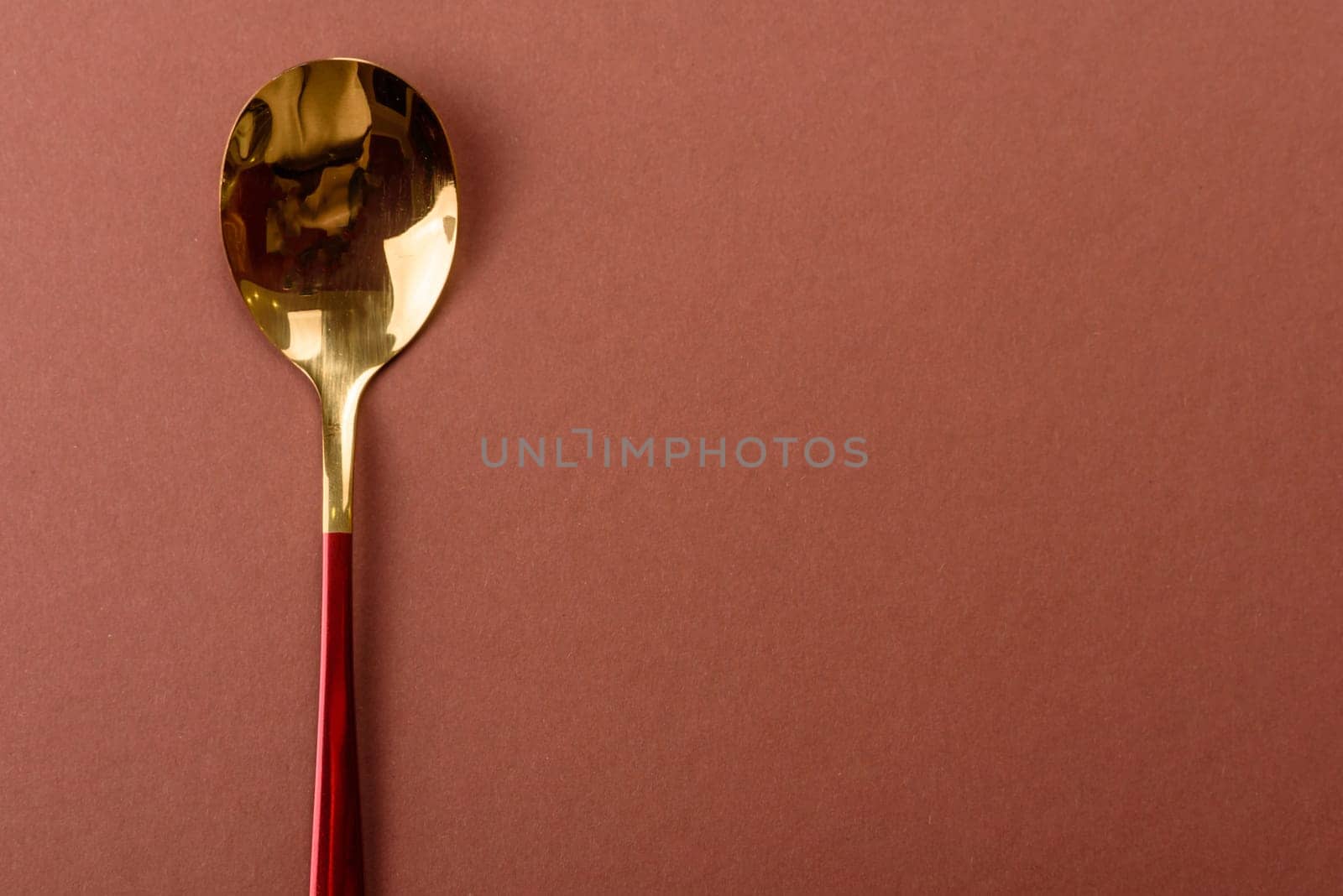 Empty metal spoon on a monochrome brown background. Cutlery on the dining table