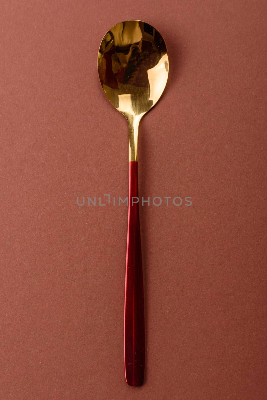 Empty metal spoon on a monochrome brown background. Cutlery on the dining table
