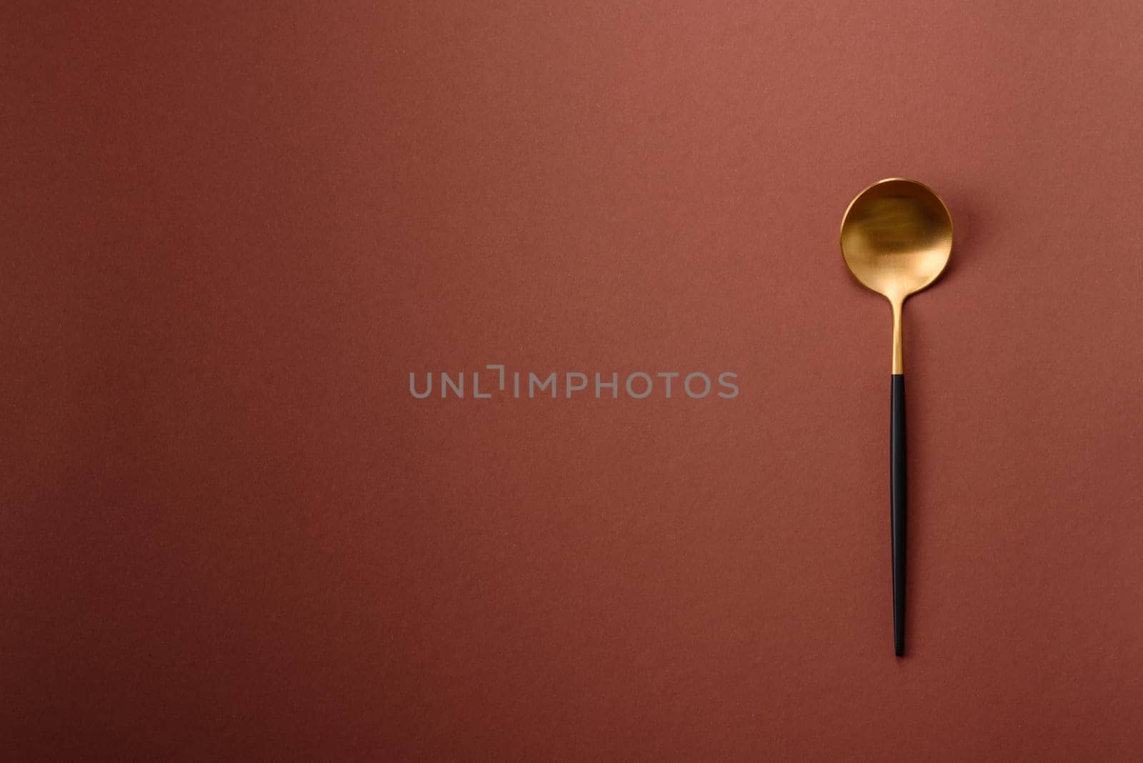 Empty metal spoon on a monochrome brown background. Cutlery on the dining table