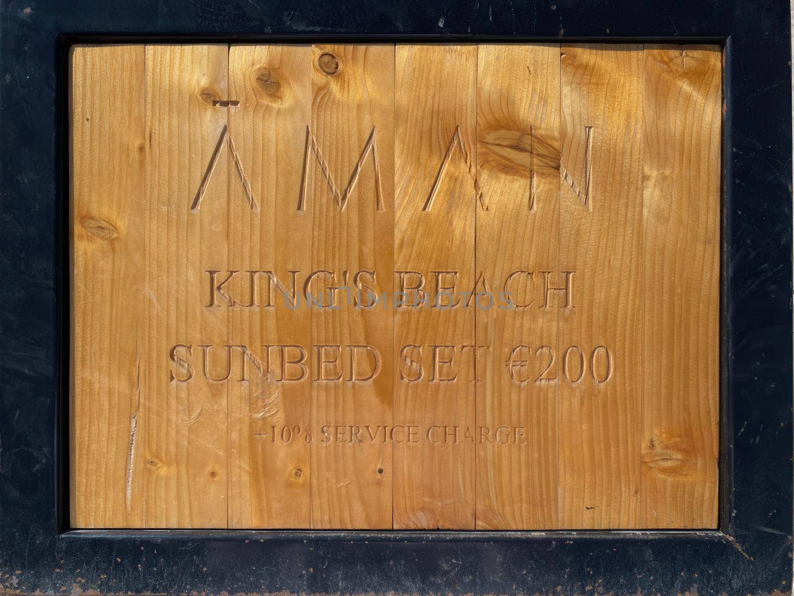 Sveti Stefan, Montenegro-September 17, 2023: wooden sign with price for sunbed -200 euros