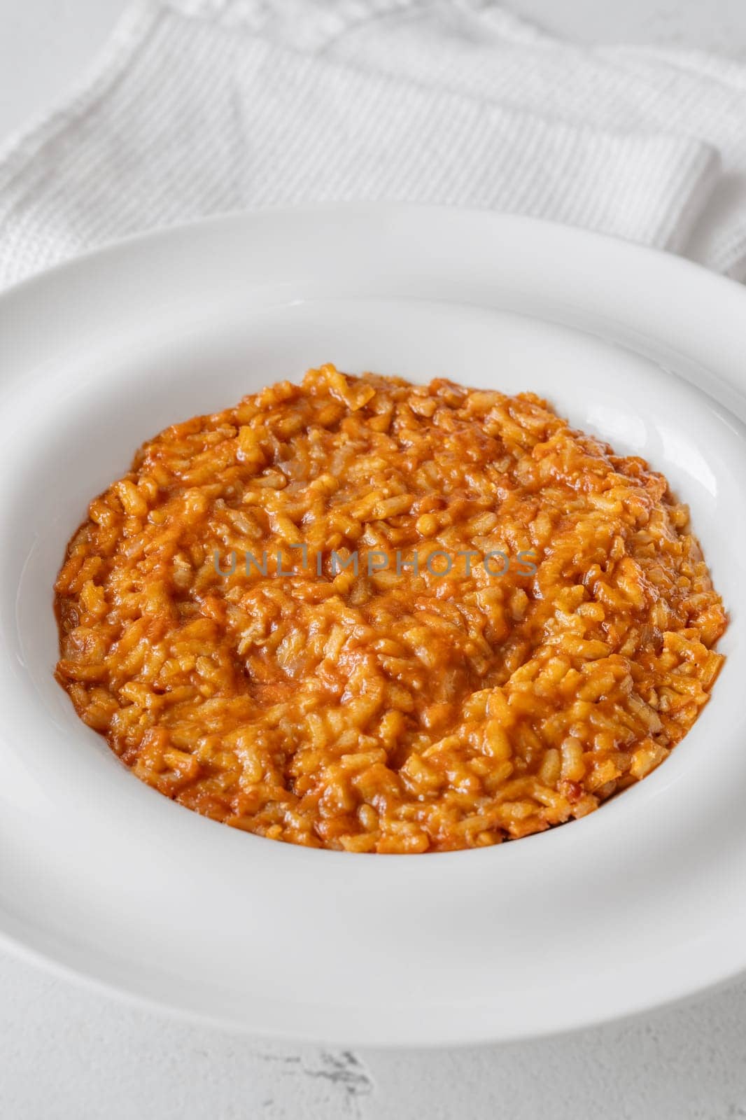 Tomato risotto plated simply with vibrant warmth