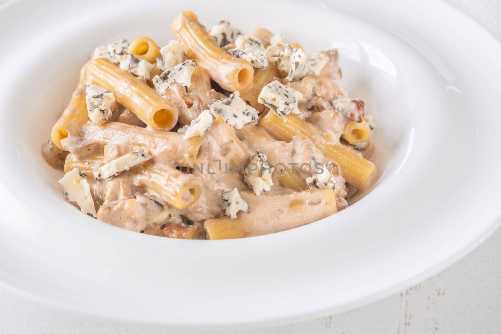 Soft penne coated in rich walnut sauce with crumbled sharp blue cheese