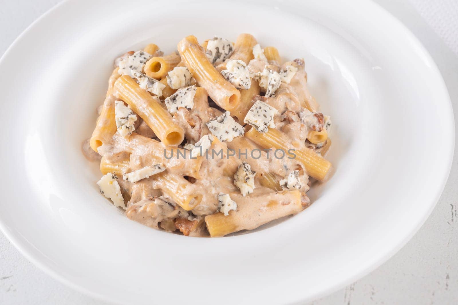 Soft penne coated in rich walnut sauce with crumbled sharp blue cheese