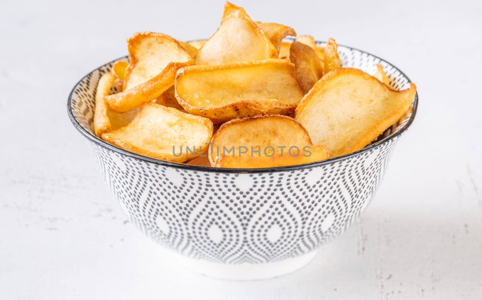 Crispy fried dippers rest warmly in bowl, perfect for salty snacking joy