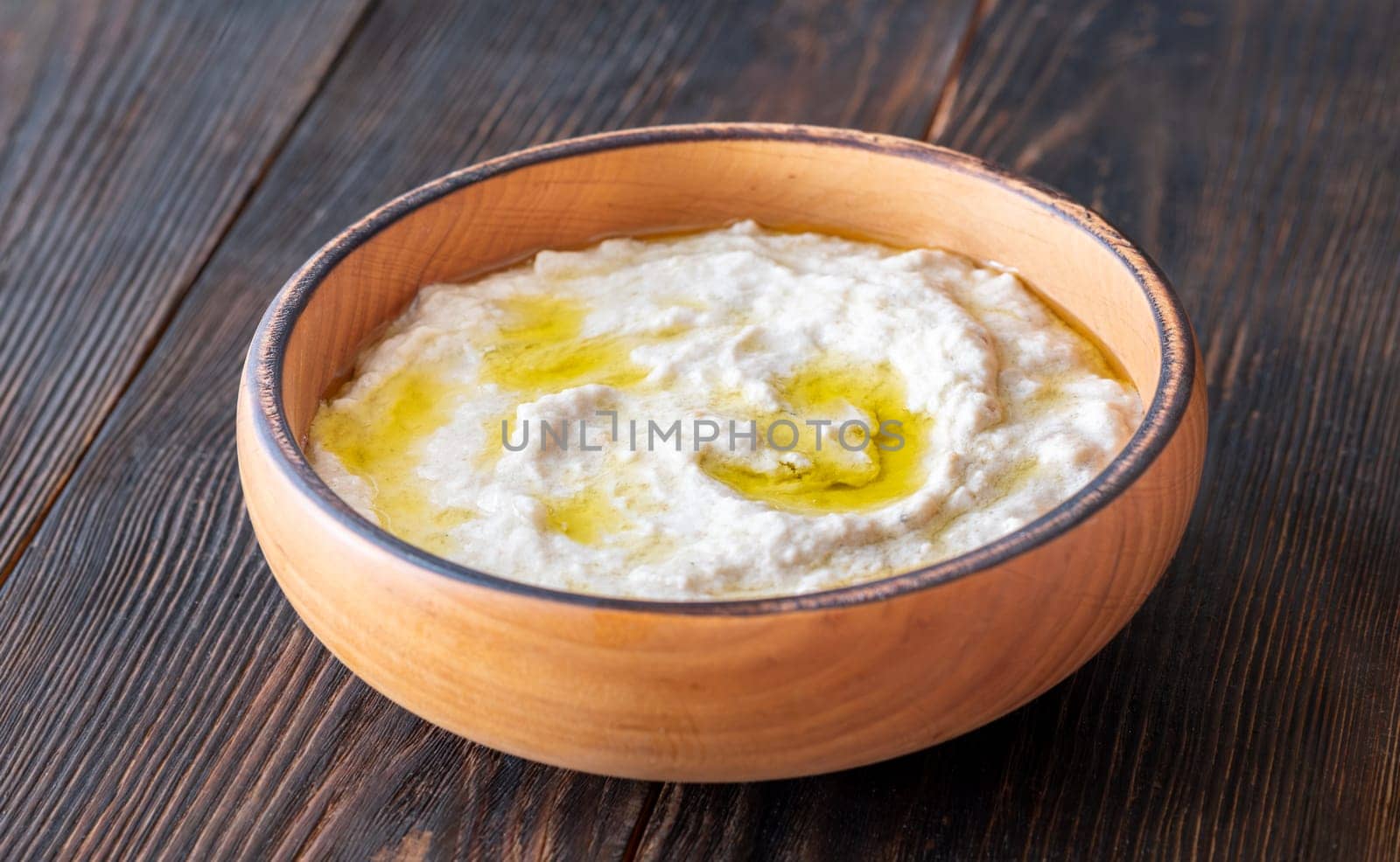 Roasted eggplant dip topped with chili flakes and oil in rustic setting