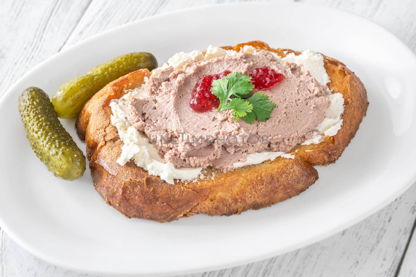 Toasted wheat sandwich with pate, creamy cheese, and tart cranberry jam