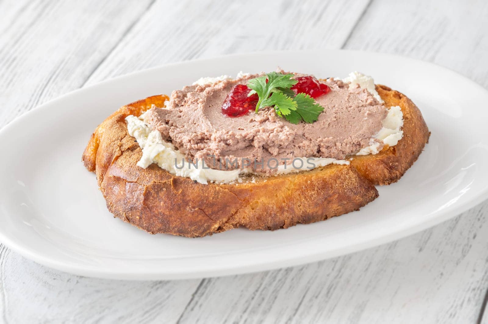 Toasted wheat sandwich with pate, creamy cheese, and tart cranberry jam