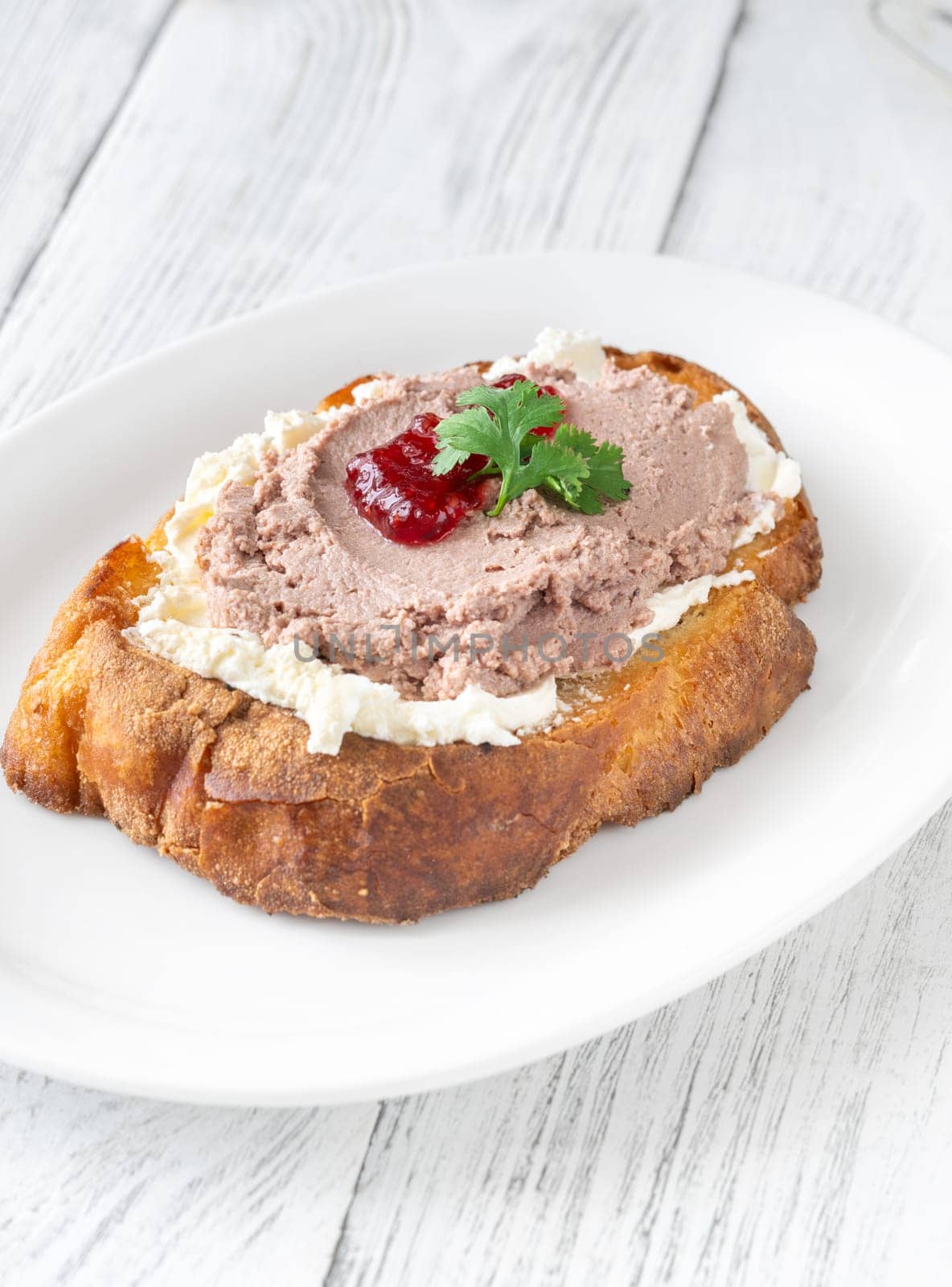 Toasted wheat sandwich with pate, creamy cheese, and tart cranberry jam
