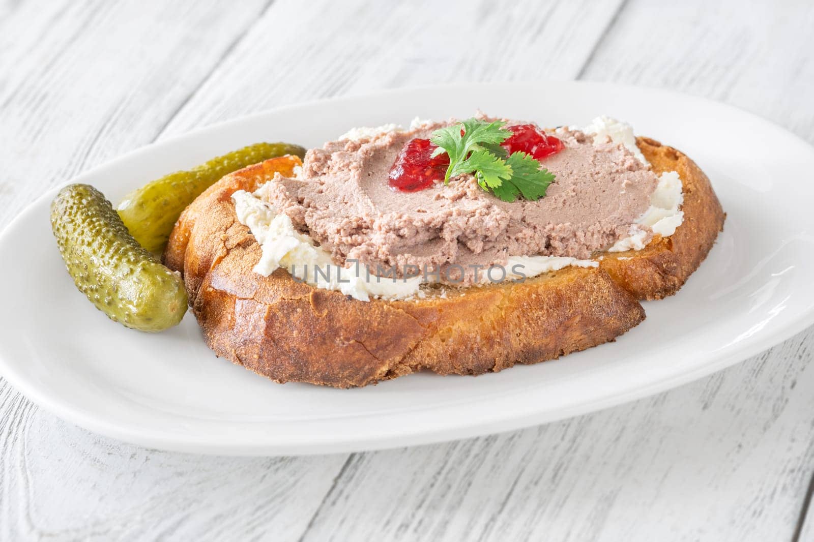 Toasted wheat sandwich with pate, creamy cheese, and tart cranberry jam