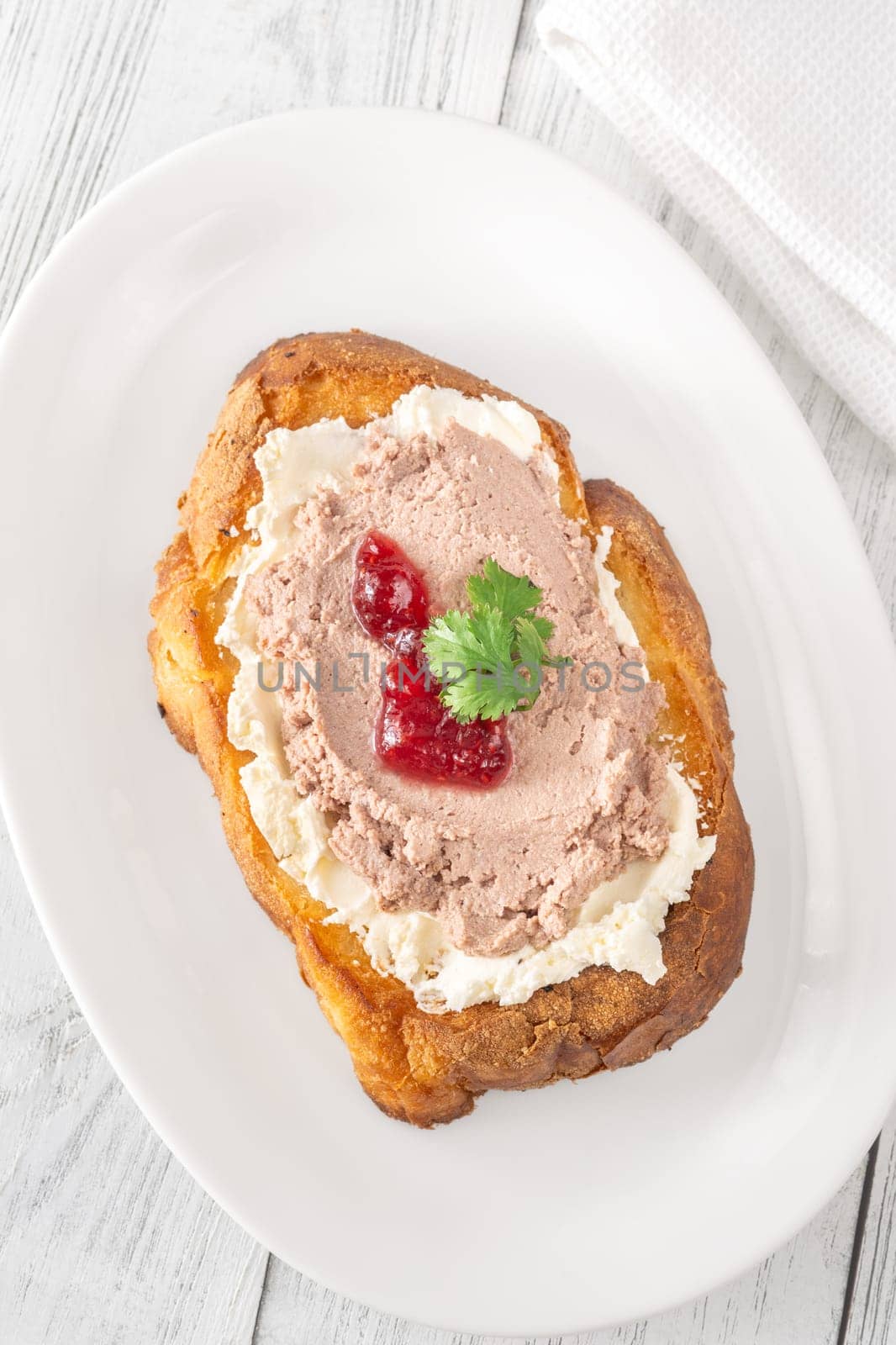 Toasted wheat sandwich with pate, creamy cheese, and tart cranberry jam