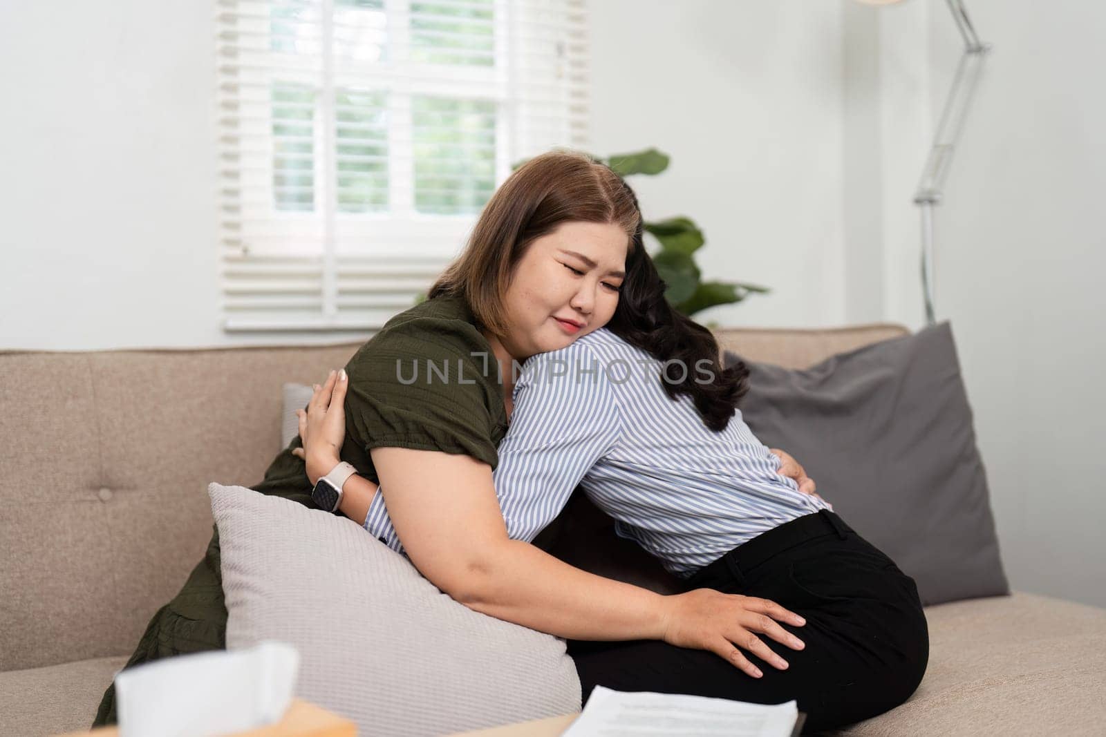 During a therapy session, a poignant moment occurs as a psychiatrist hugs her client, reinforcing the bond of trust and emotional support.