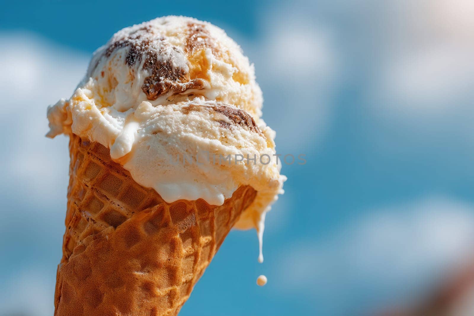 Delicious vanilla and caramel swirl ice cream melting in a crispy waffle cone against a clear blue sky. Perfect for dessert packaging, advertising, summer campaigns, and food styling