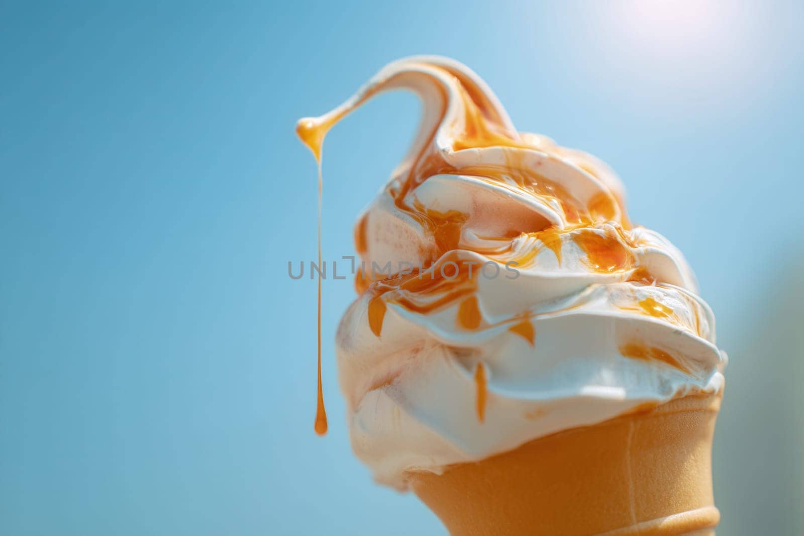 A close-up of creamy soft-serve ice cream drizzled with golden caramel sauce, set against a sunny blue sky. Great for dessert branding, summer ads, food packaging, and sweet treat visuals
