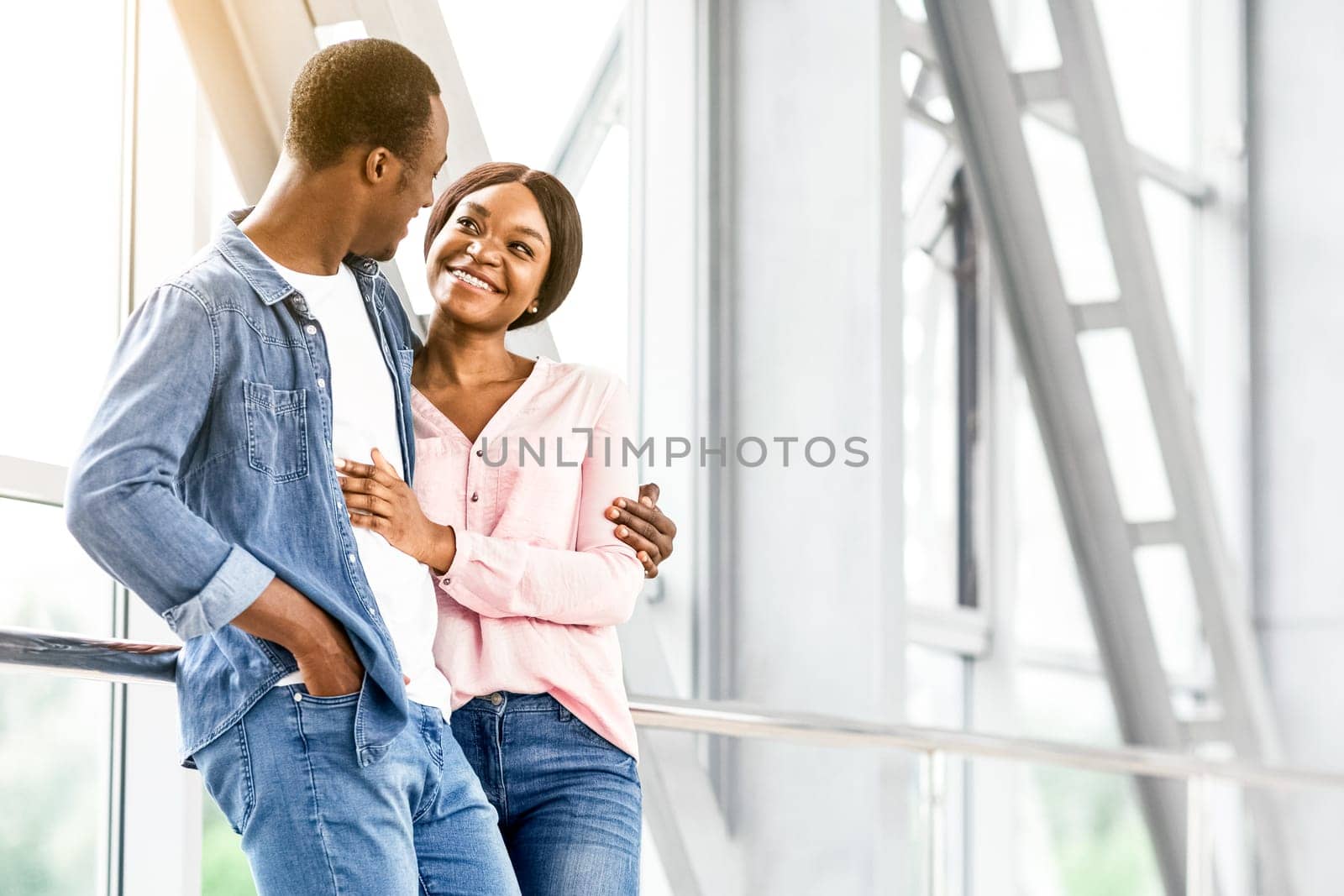 Ready For Romantic Travel. Black Couple In Love Waiting For Flight At Airport Terminal, Hugging And Smiling, Copy Space