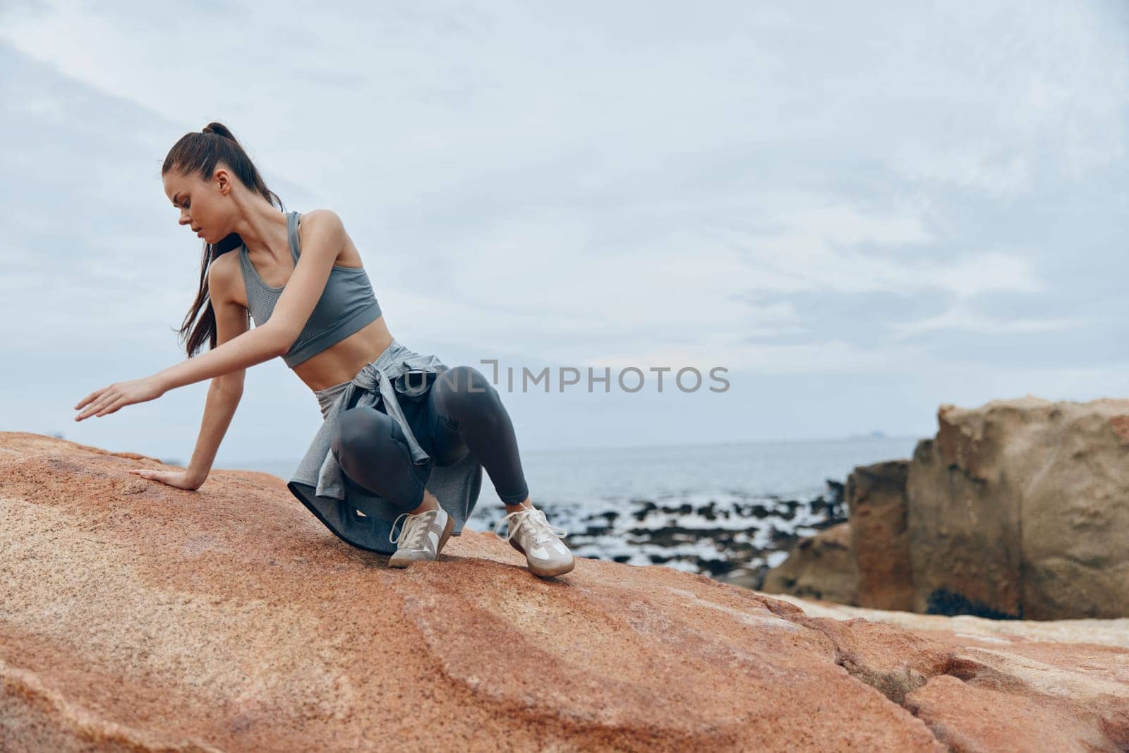 Athletic woman in trendy sportswear enjoys the beach, promoting health and wellness with a tranquil ocean view A perfect representation of fitness and nature
