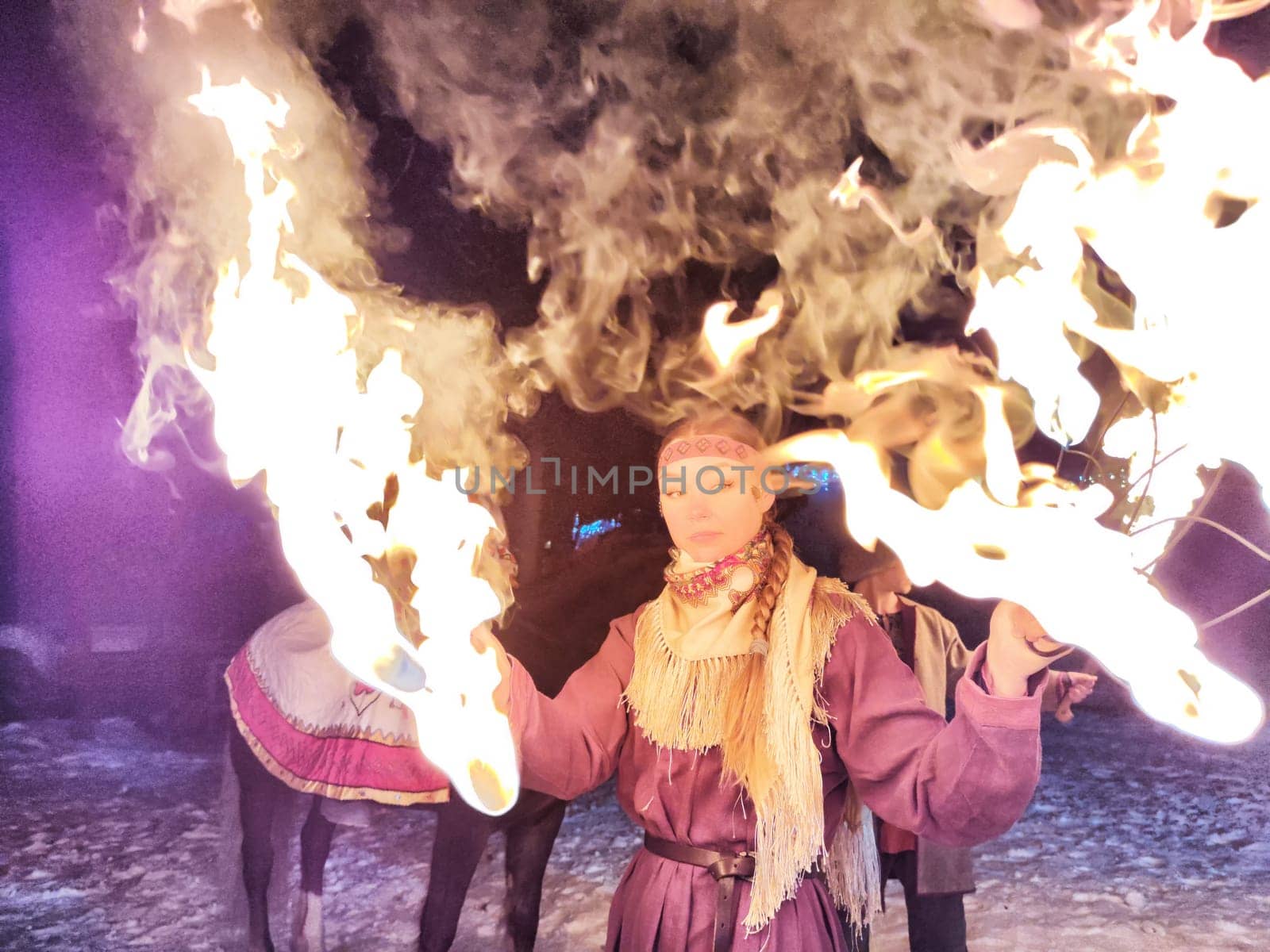 Actors in ethnic costumes deliver a mesmerizing fire show on a cold winter night, highlighting Viking culture and bravery.