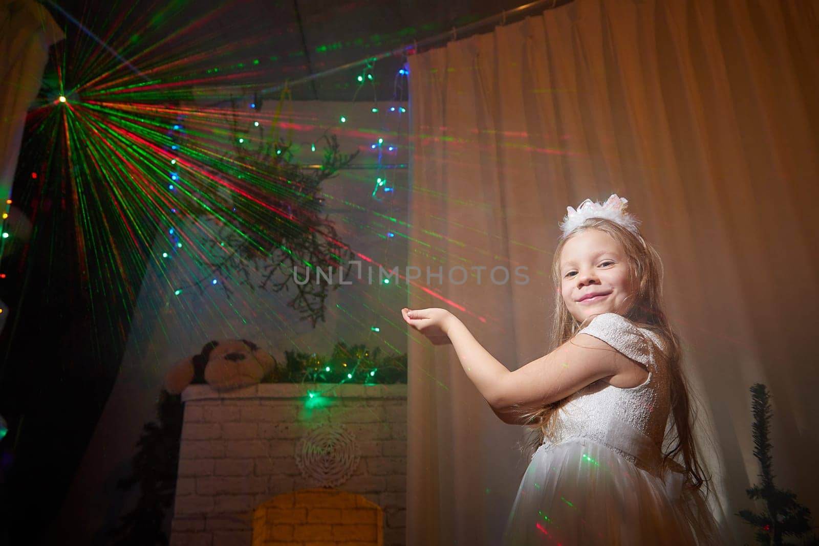 A cheerful child in a festive dress spreads joy among colorful lights and decorations during Christmas celebrations.
