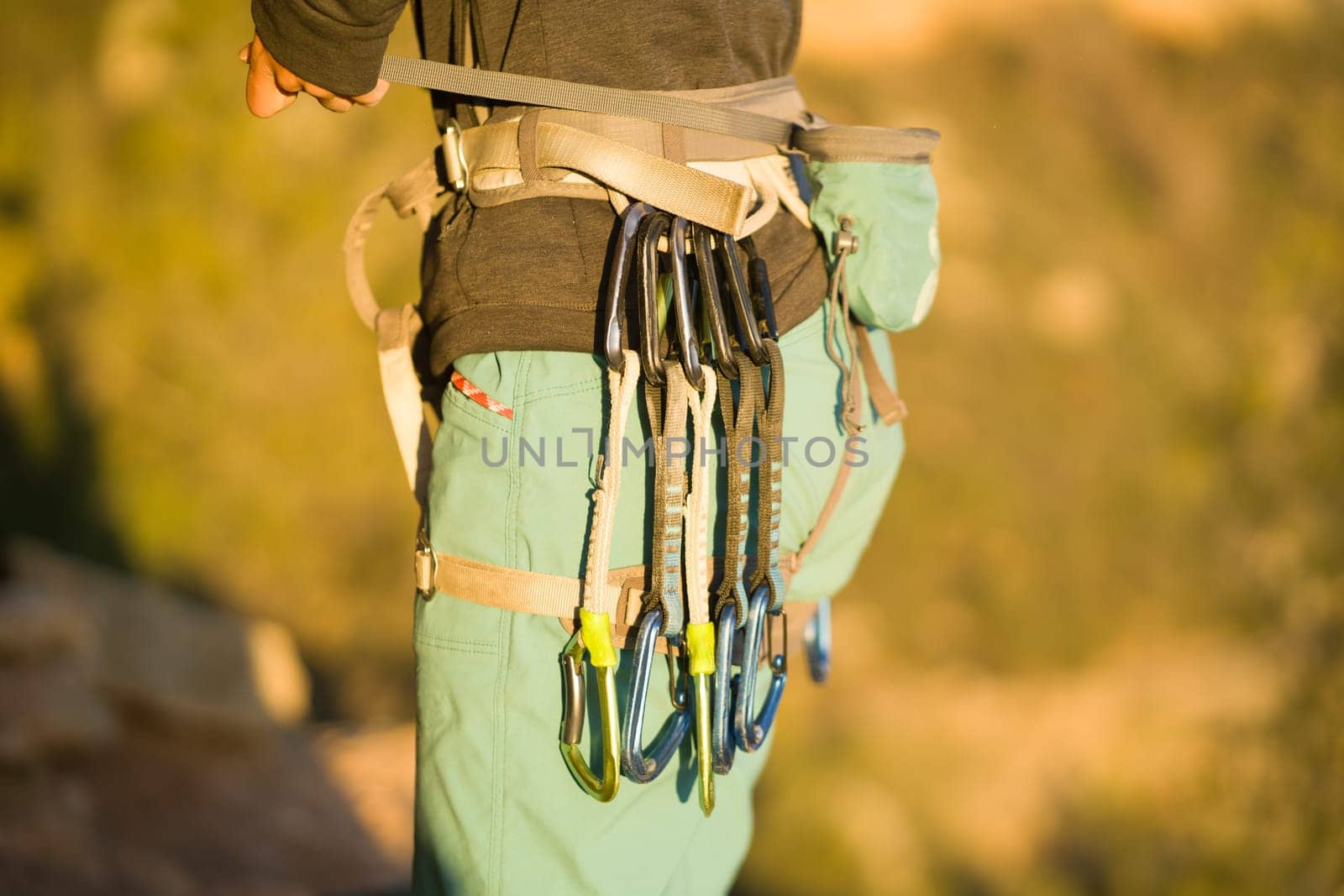 A young girl is engaged in active sports, rock climbing and mountaineering. A woman looks at a beautiful red rock and takes magnesia in her hand, getting ready for training and climbing.