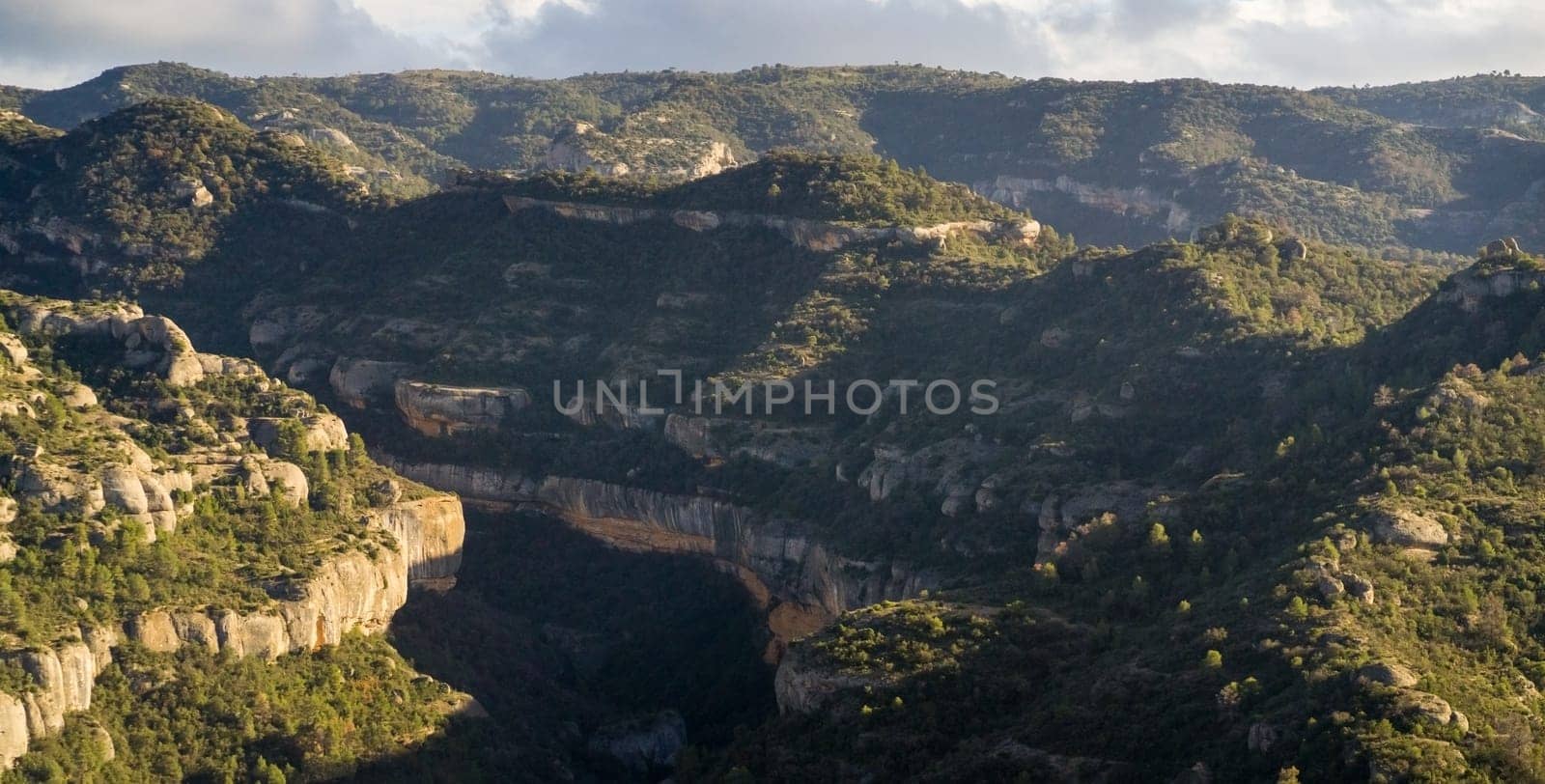 Beautiful road among the rocky yellow-red mountains on the southern mediterranean coast in the rays of the sun at sunset.