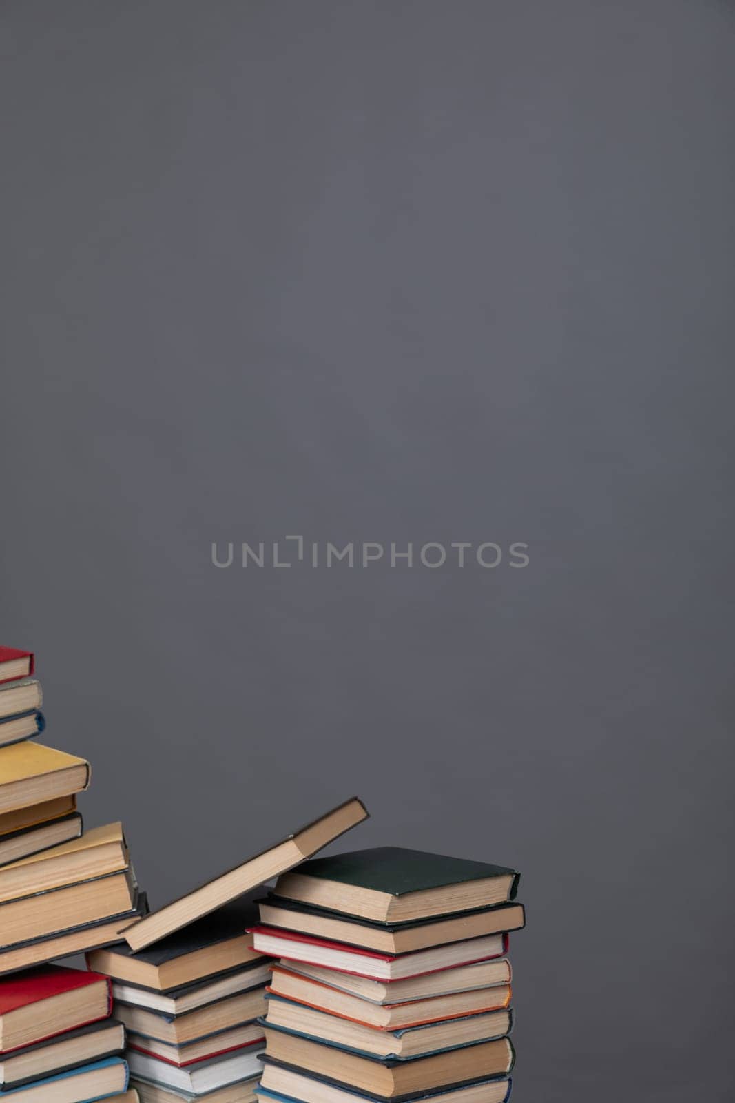 Stacks of old educational books for teaching in the library on a gray background at school university