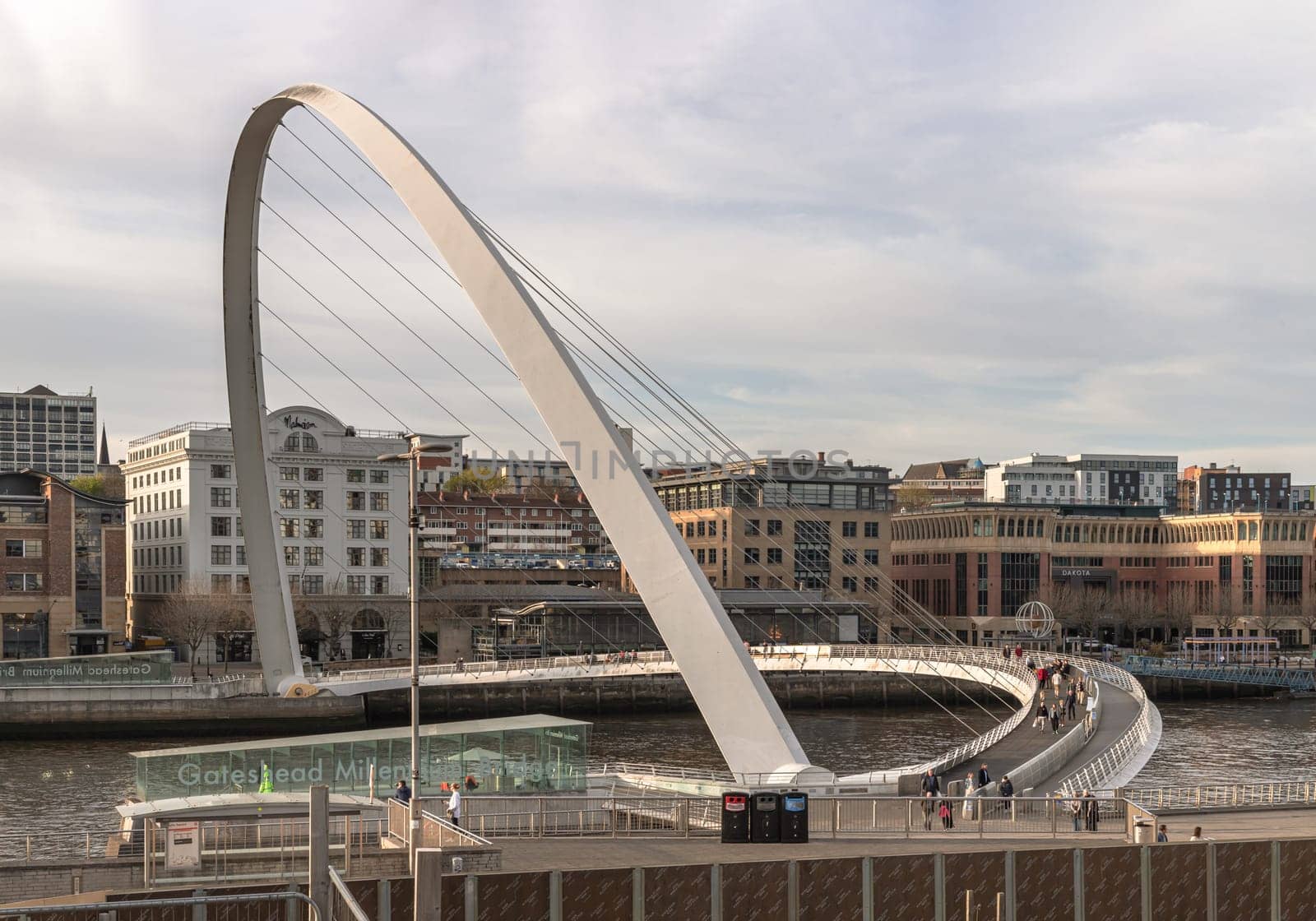 Newcastle, UK - Apr 11, 2025 - A view of The Iconic gateshead millennium bridge spanning the River Tyne with historical buildings at the background in Newcastle Upon Tyne in the North East of England. The pedestrian bridge, use it as your Wallpaper, Poster and Space for text, Selective focus.