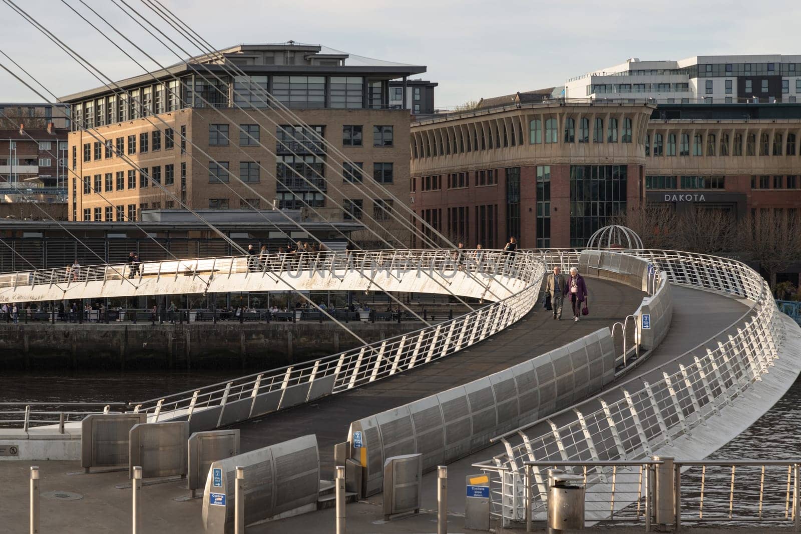 Newcastle, UK - Apr 11, 2025 - A view of The Iconic gateshead millennium bridge spanning the River Tyne with historical buildings at the background in Newcastle Upon Tyne in the North East of England. The pedestrian bridge, use it as your Wallpaper, Poster and Copy space, Selective focus.