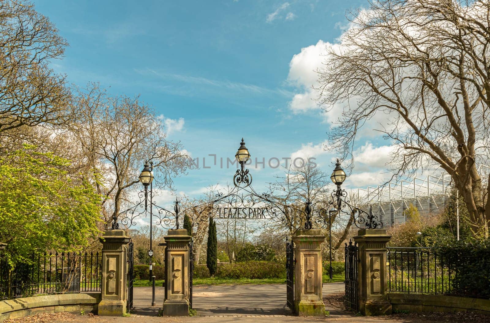 Newcastle, UK - Apr 13, 2025 - View of Cast iron lamp over the Wrought iron gate is open to the entrance of Leazes park with beautiful sky background. use it as your Wallpaper, Poster and Space for text, Selective focus.