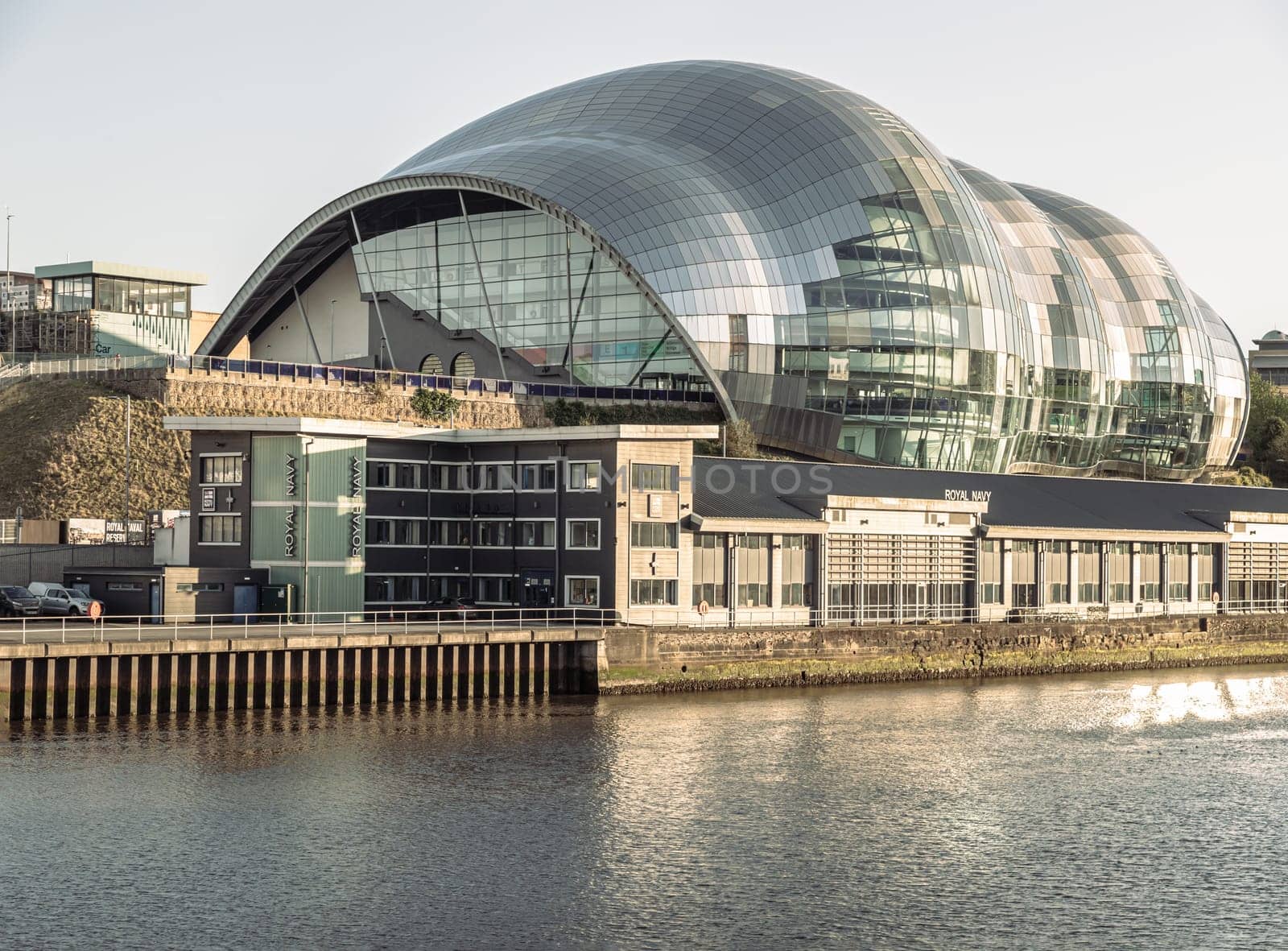 Newcastle, UK - Apr 11, 2025 - Architecture exterior view of The Glasshouse International Centre for Music or Sage Gateshead by the River Tyne before sunset. Modernist futuristic glass building, A concert venue and cultural centre in the city of Newcastle upon Tyne in Northumberland, use it as your Wallpaper, Poster and Copy space, Selective focus.