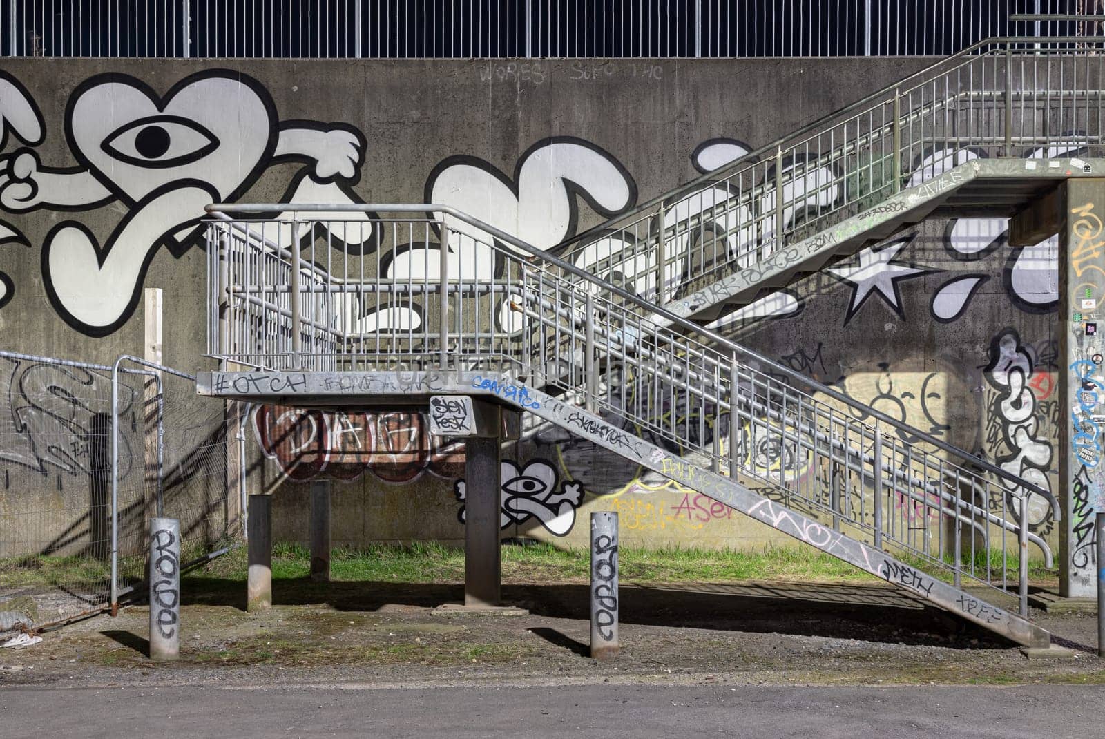 Newcastle, UK - Apr 13, 2025 - A staircase with Street art graffiti walls by the River tyne. Silver steel stairs descend from textured walls toward graffiti decorated lower levels, use it as your Wallpaper, Poster and Space for text, Selective focus.
