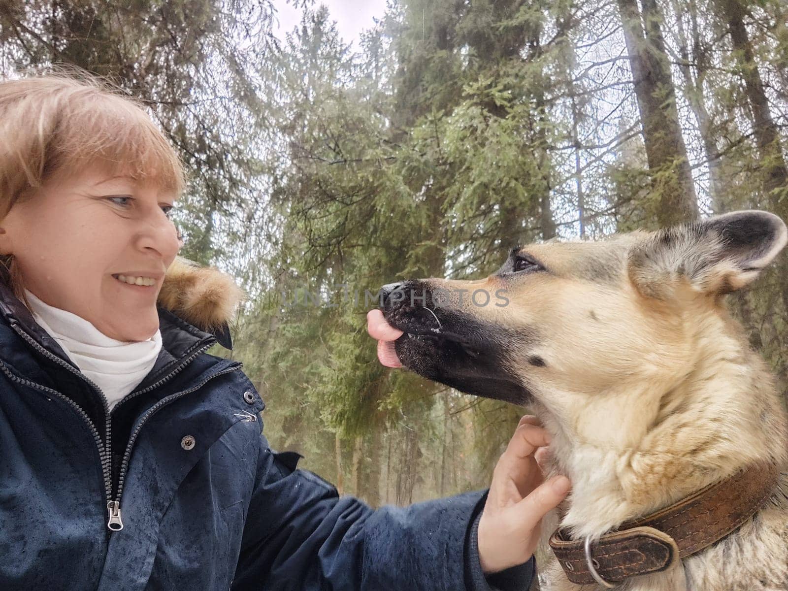 A woman shares a joyful interaction with her dog in a dense green forest, capturing the essence of their adventure together.