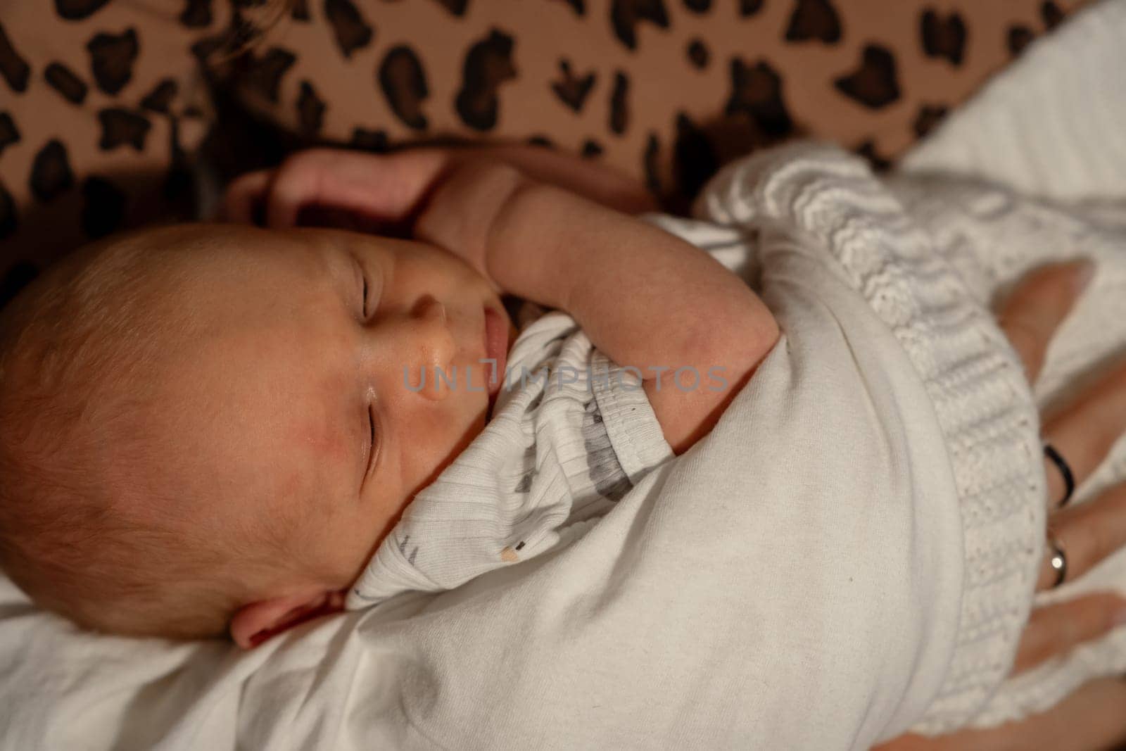 In a warm, comforting environment, a mother peacefully holds her newborn baby, emphasizing the close bond and love shared in this intimate moment.