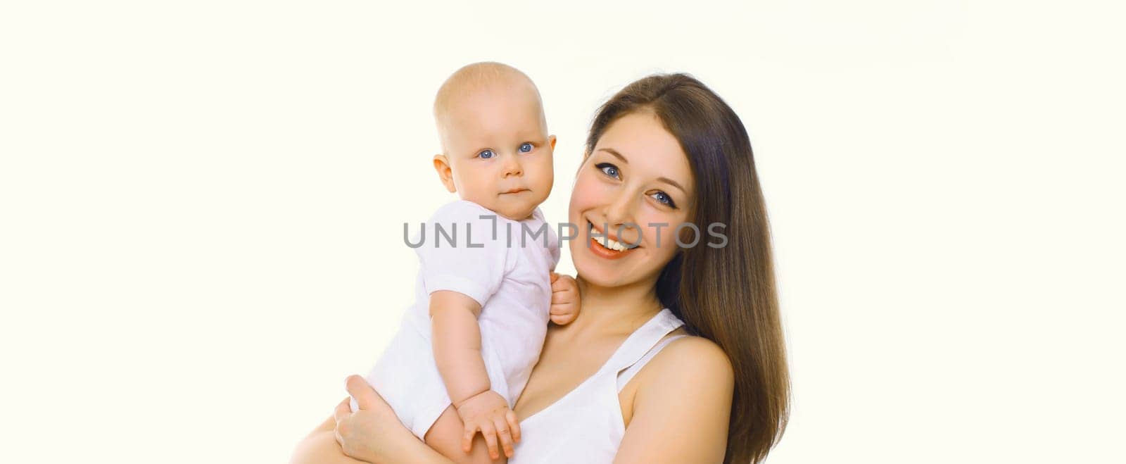 Portrait of happy cheerful smiling mother holding her baby, joyful young mom and little child on white studio background