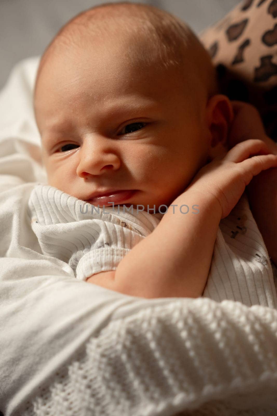 A mother lovingly holds her newborn baby close in a serene setting, creating a nurturing bond in a cozy atmosphere during the day.