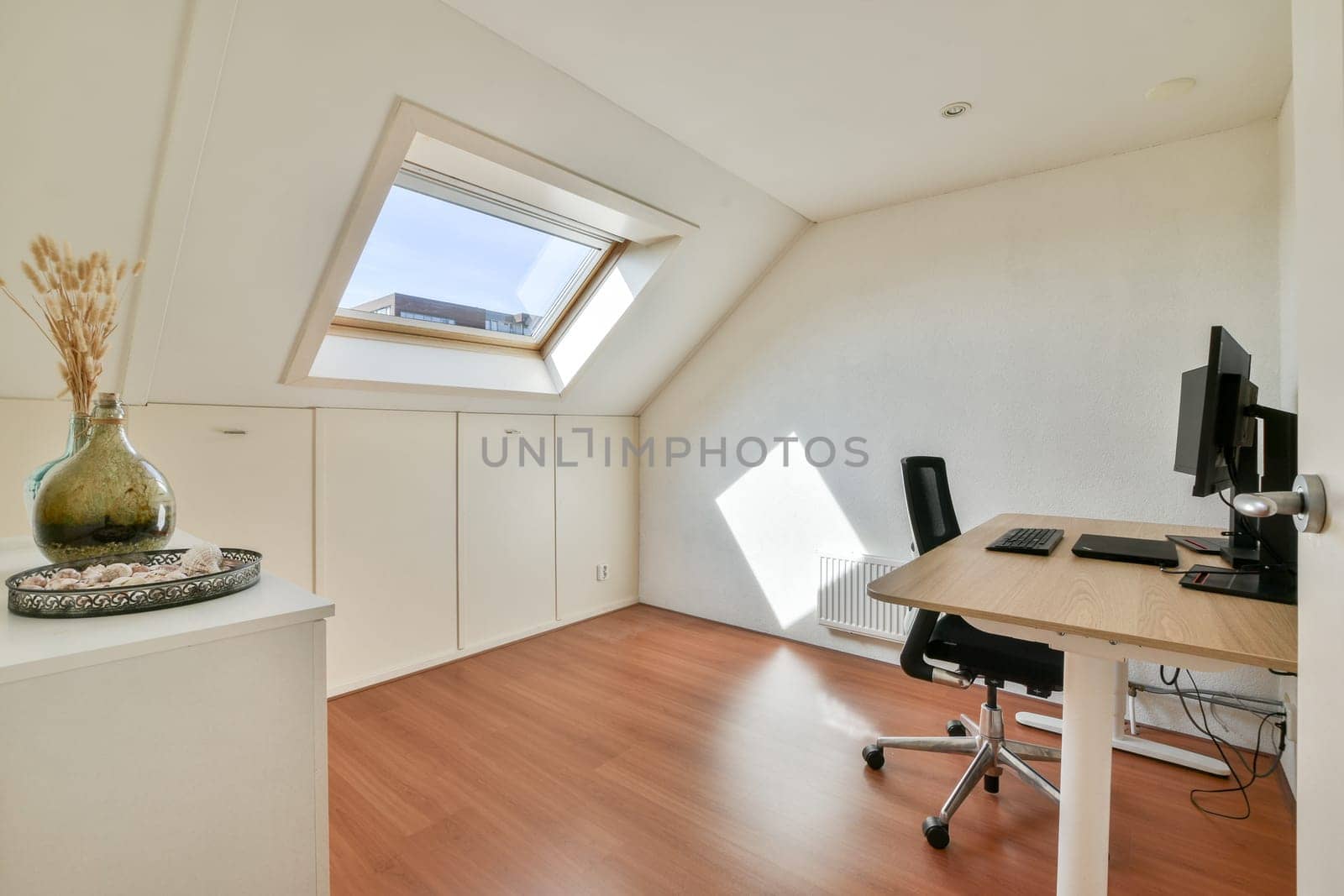 A bright and airy modern home office featuring a sleek desk, ergonomic chair, and decorative vase, ideal for productivity and comfort.