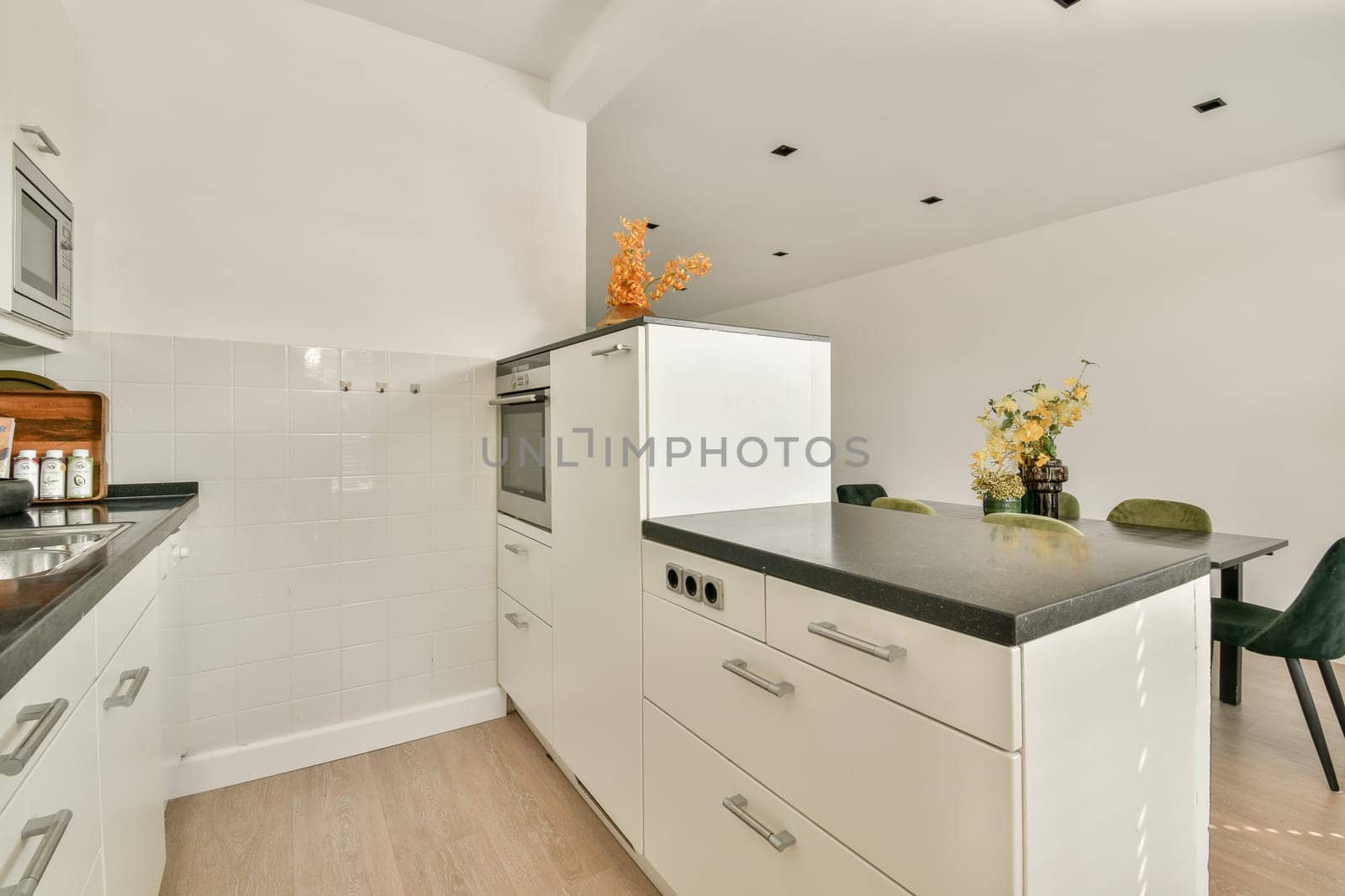 A sleek modern kitchen featuring minimalistic cabinetry, a stylish countertop, and subtle decorative elements, creating a spacious feel.