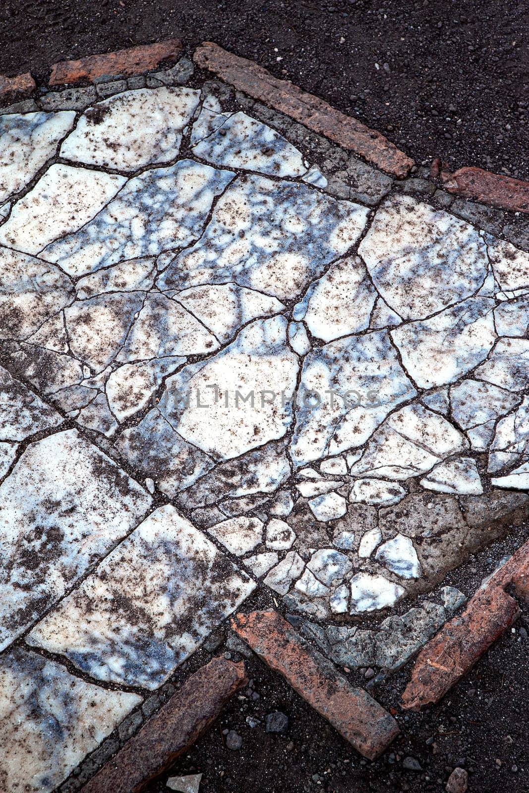 Broken marble slab on dirt floor