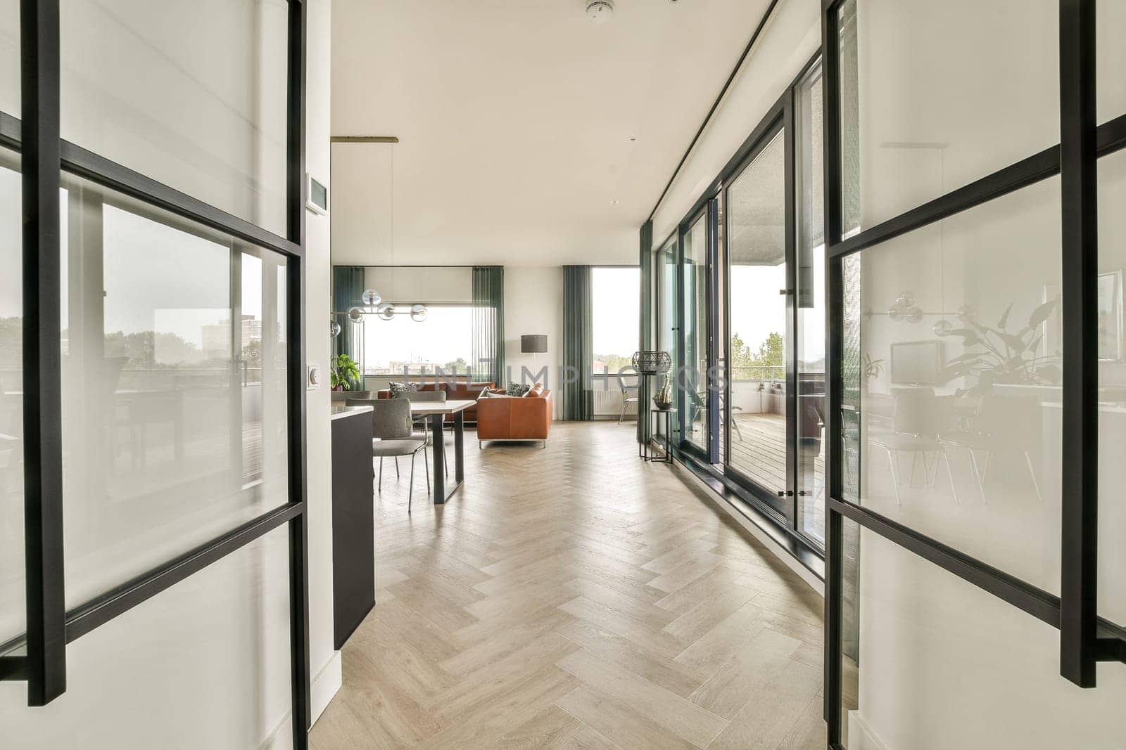A stylish modern interior showcasing an open layout with large windows, vibrant furniture, and elegant decor elements that create a welcoming atmosphere.