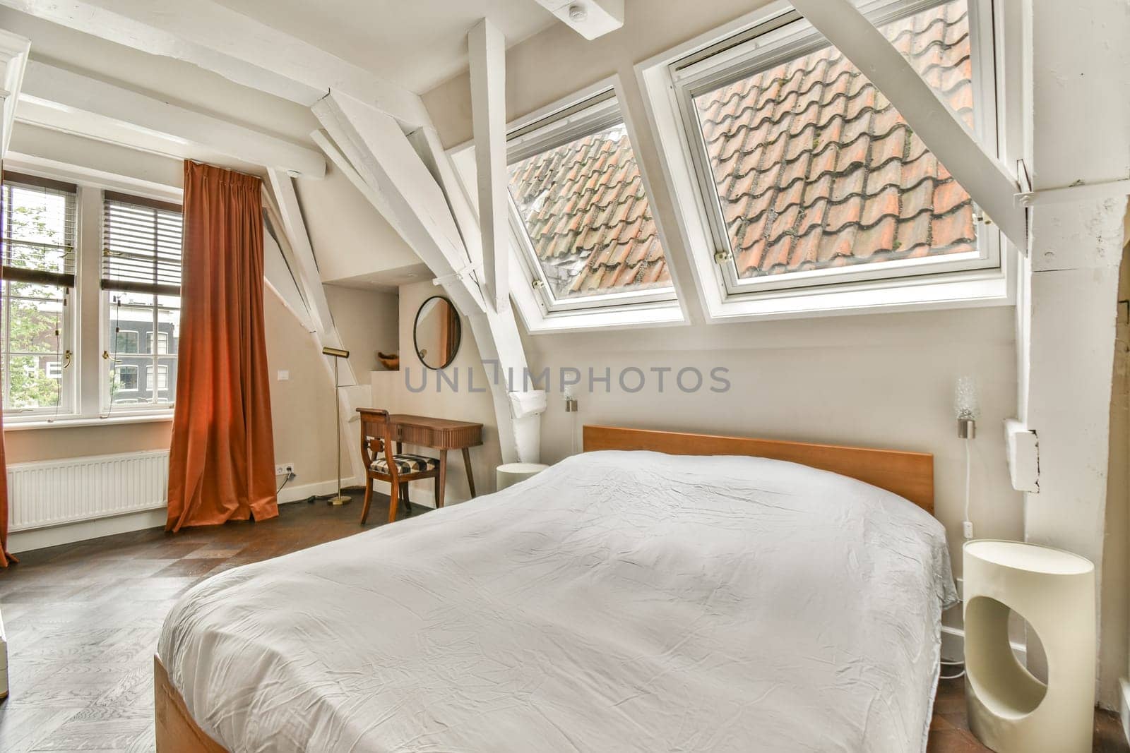 A beautifully designed modern bedroom featuring large windows that allow plenty of natural light, creating a warm and inviting atmosphere.