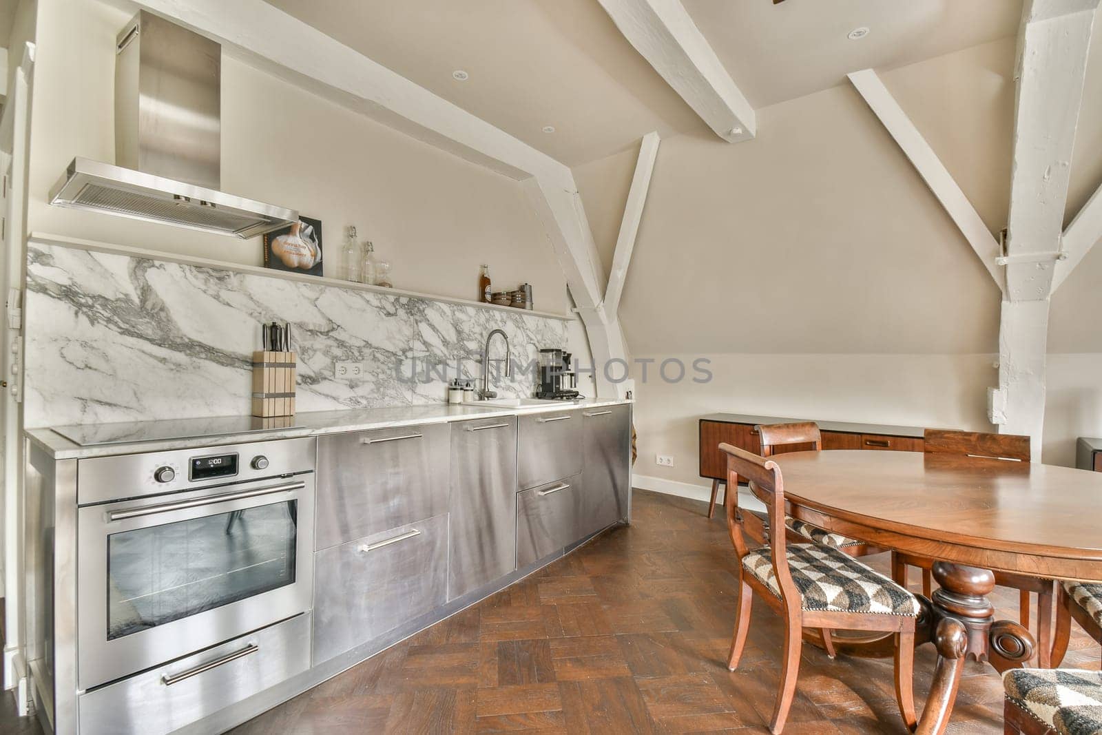 Stylish modern kitchen featuring sleek cabinetry, a marble backsplash, and wooden flooring. Ideal for contemporary home designs and culinary enthusiasts.