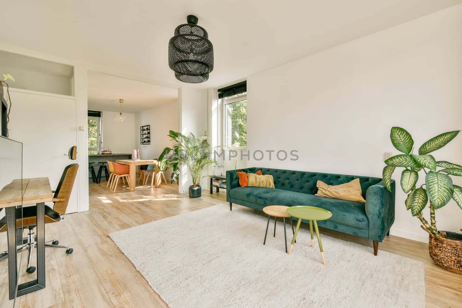 A stylish living room showcasing modern furniture and decor, with ample natural light and greenery, creating a warm and welcoming atmosphere.