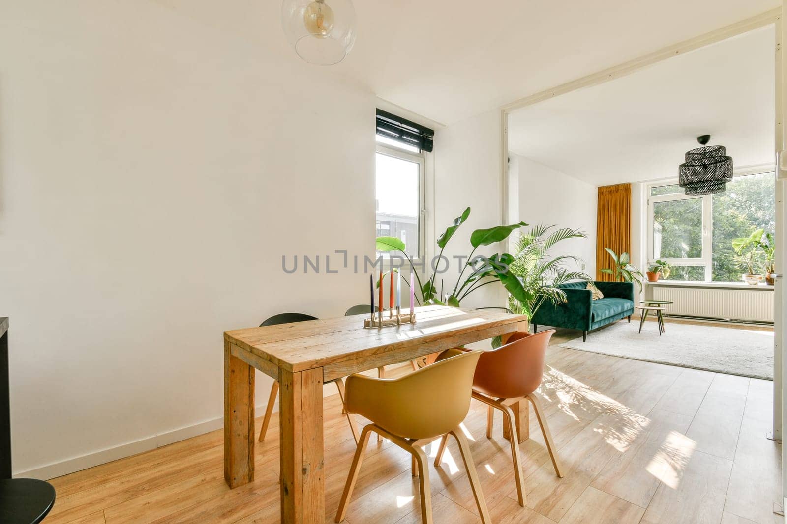 Stylish and modern interior featuring a wooden dining table, comfortable seating, and large windows bringing in natural light. A blend of functionality and elegance.