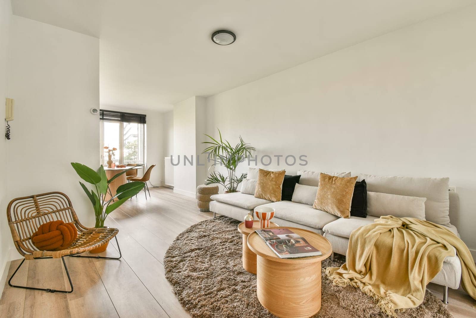 A serene modern living room featuring cozy furniture, soft textures, and natural light, creating a warm inviting atmosphere for relaxation.