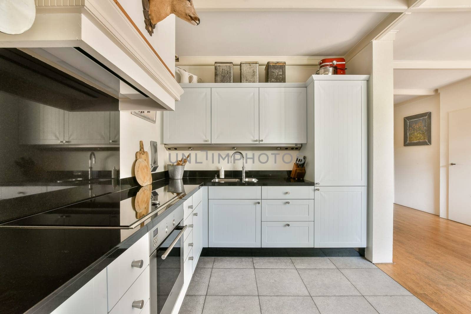 A sleek and stylish modern kitchen featuring white cabinetry, black countertops, and an open design that enhances the space. Perfect for culinary enthusiasts.