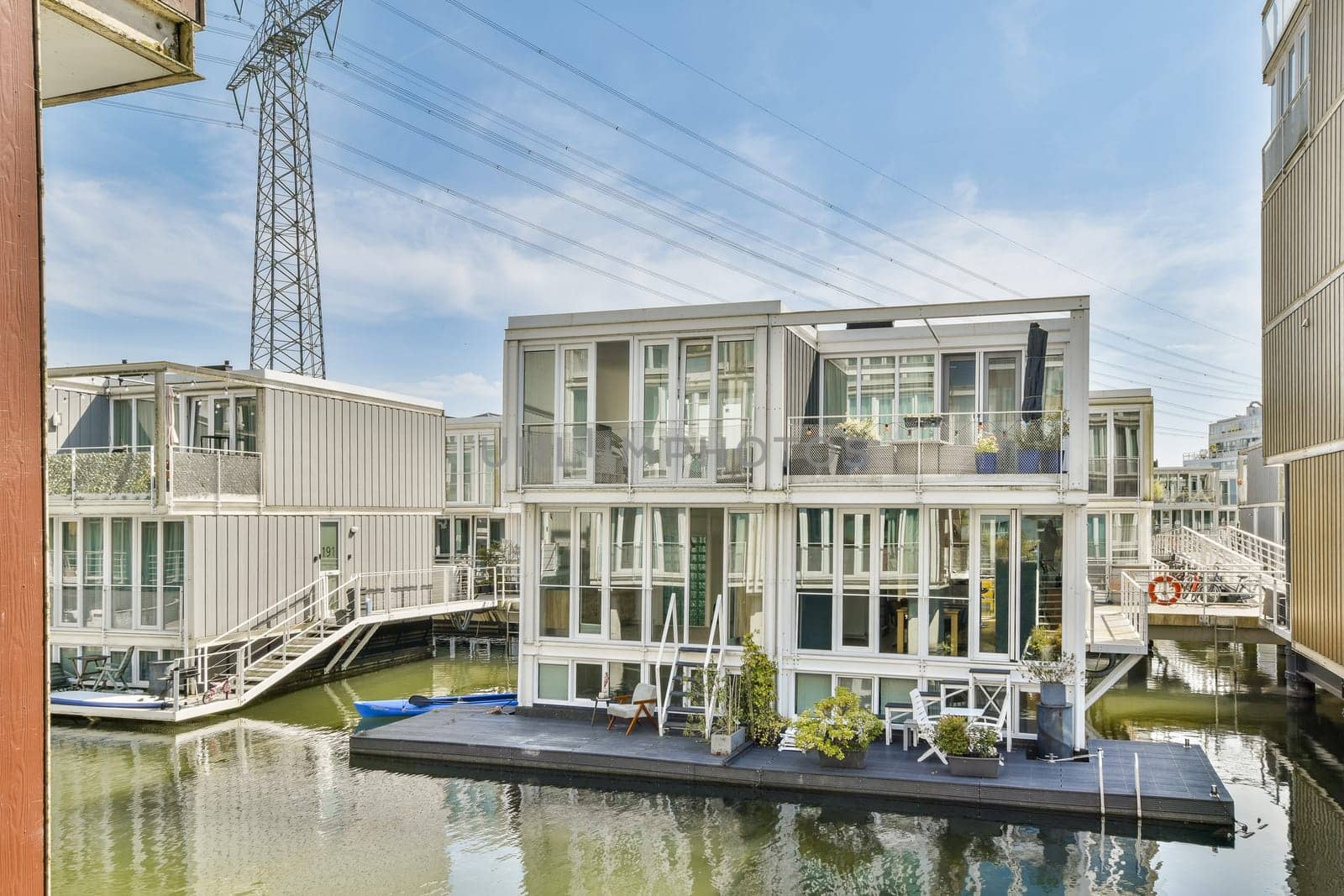 A picturesque view of contemporary floating houses lining a tranquil waterway, showcasing unique architecture and serene surroundings.
