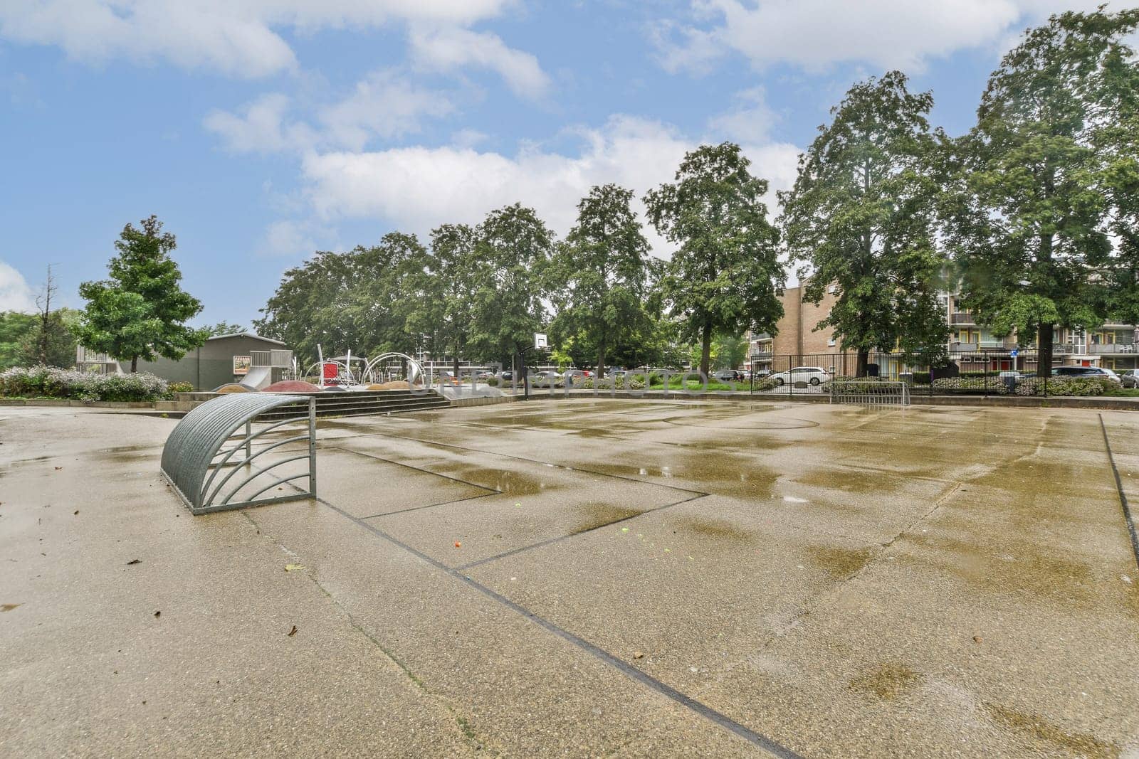 A serene urban park featuring lush green trees, a modern pavilion, and a smooth pavement leading through the peaceful environment, ideal for relaxation.