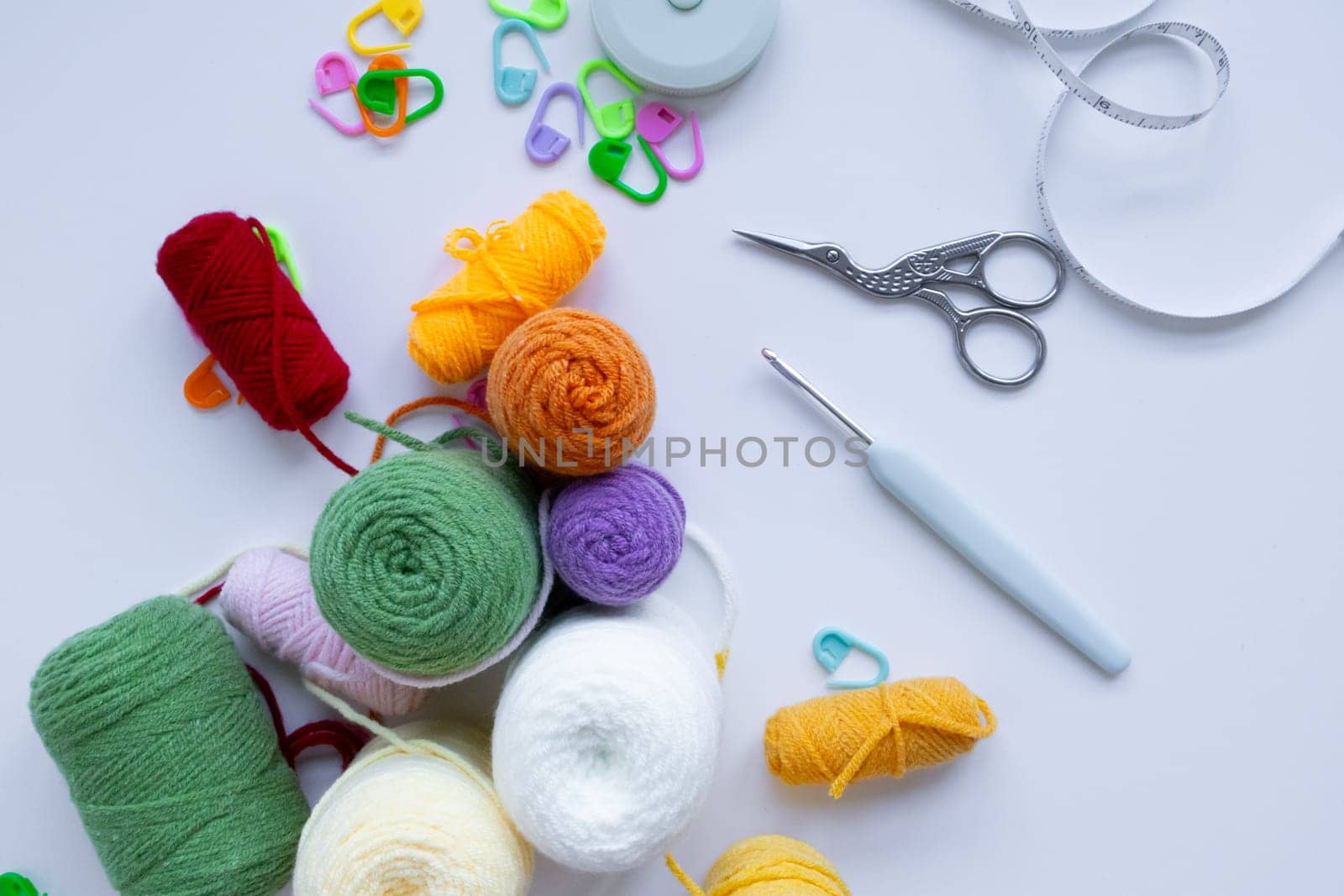 Colorful yarn and crochet tools on white background.