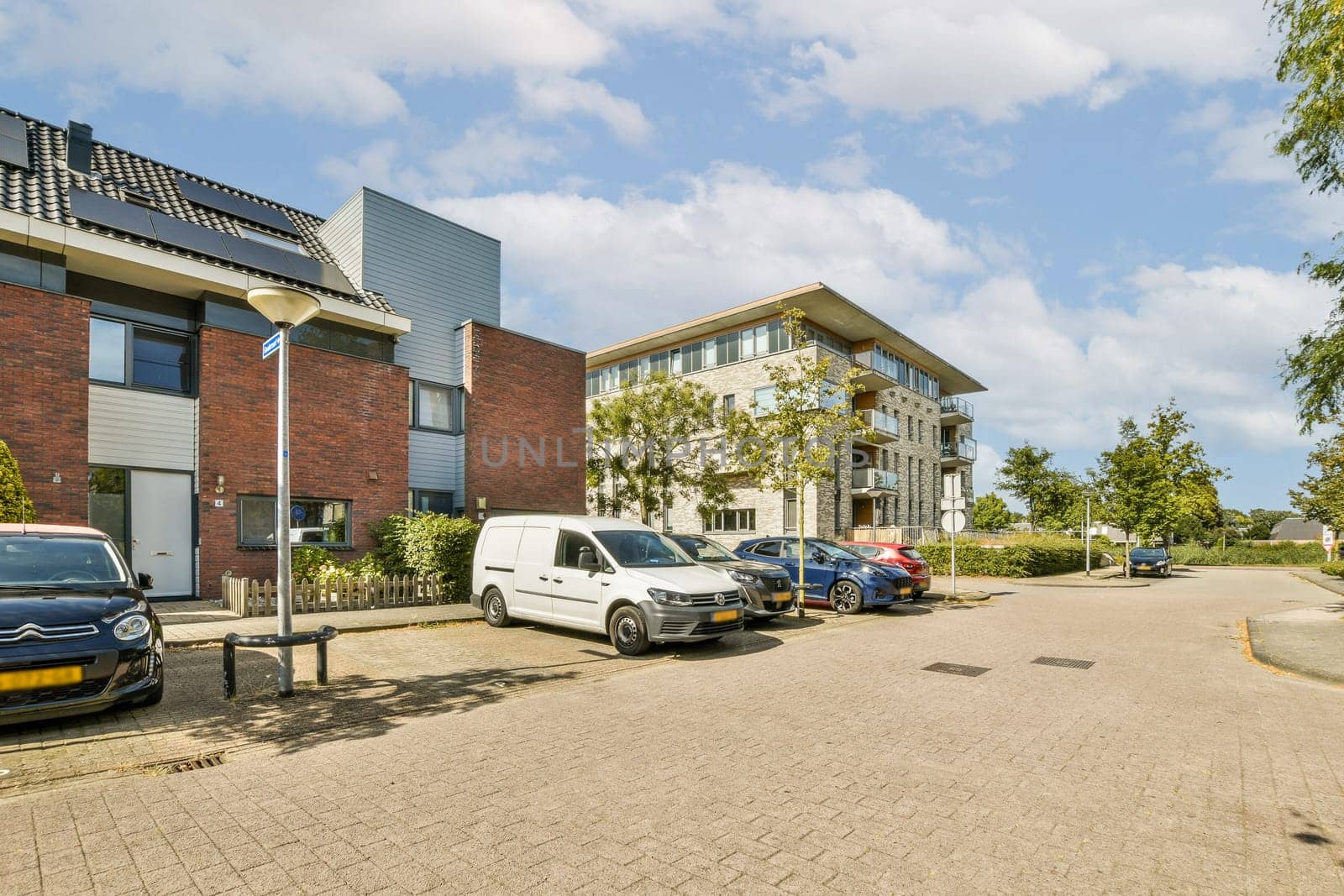 A scenic view of a modern residential street showcasing contemporary buildings and parked vehicles offering an inviting atmosphere.