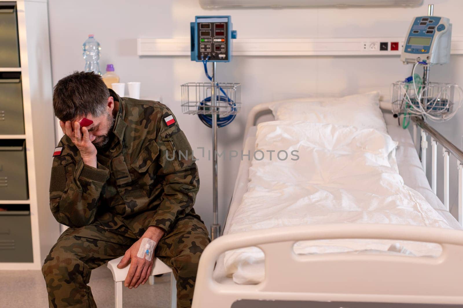 A soldier sits alone in a hospital, visibly distressed, reflecting the emotional toll of their service experience