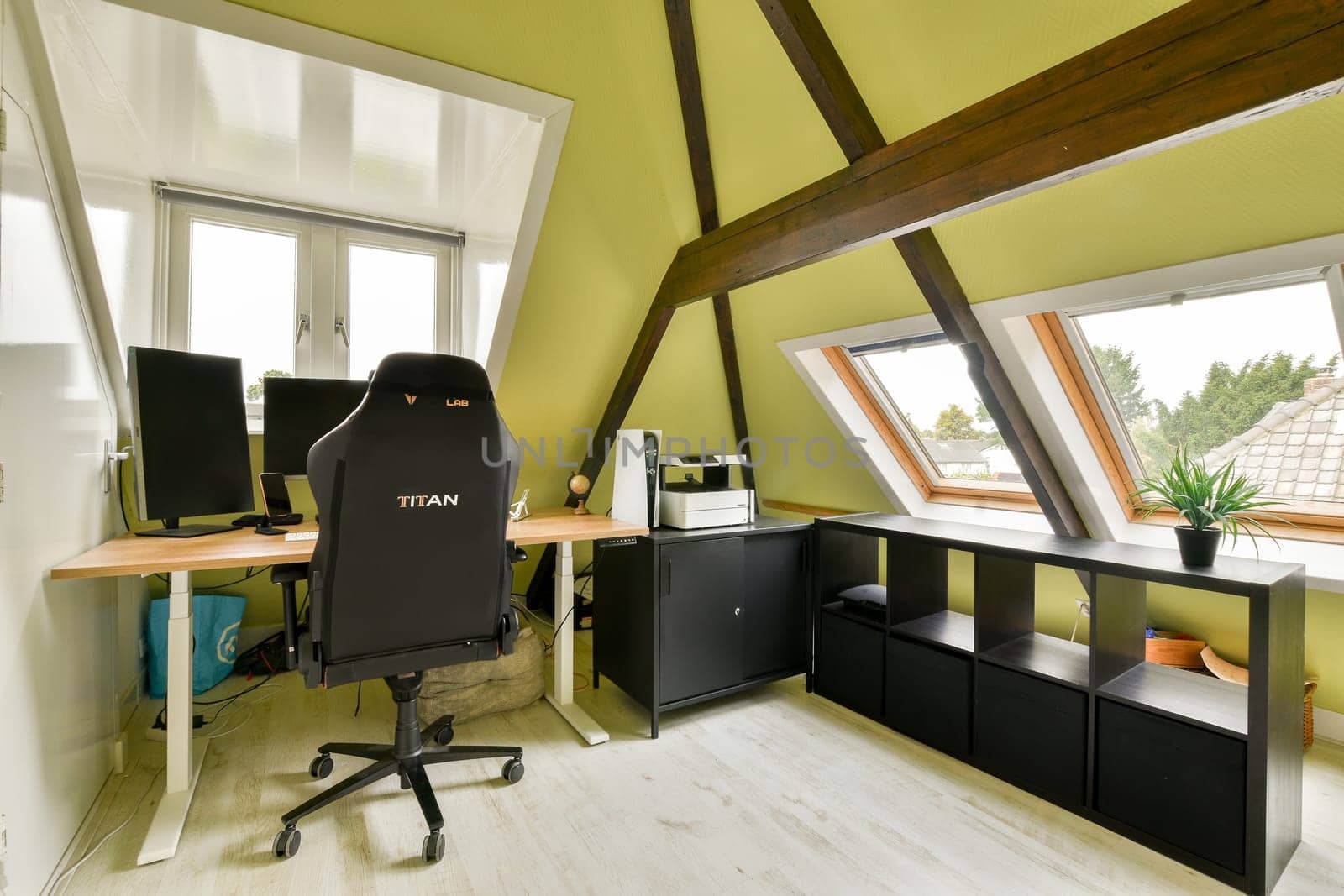 A stylish home office space featuring a comfortable chair, desk, and large windows for ample natural light, creating an inspiring work environment.