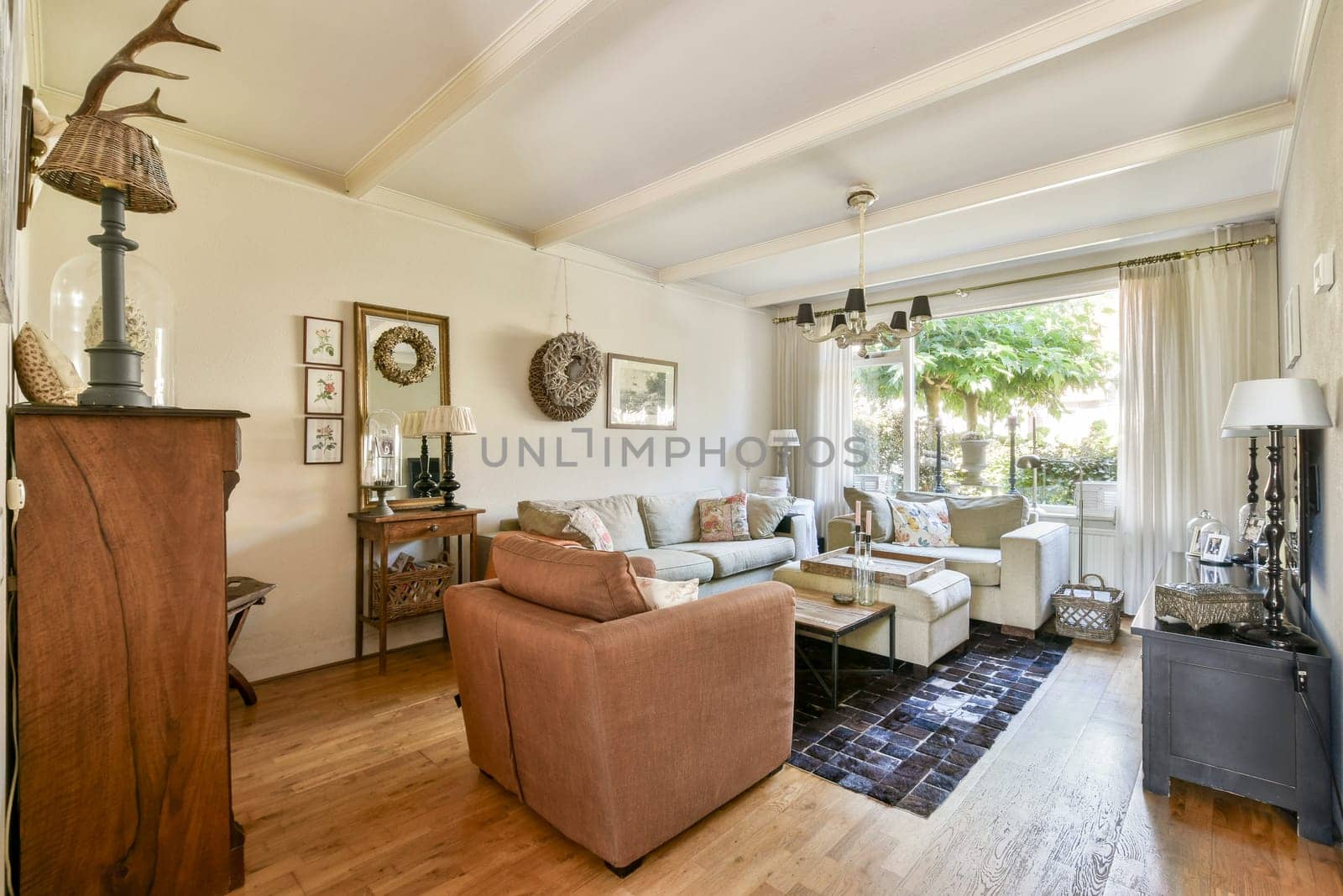 A stylish living room with comfortable seating, wooden accents, and large windows allowing plenty of natural light to brighten the space.